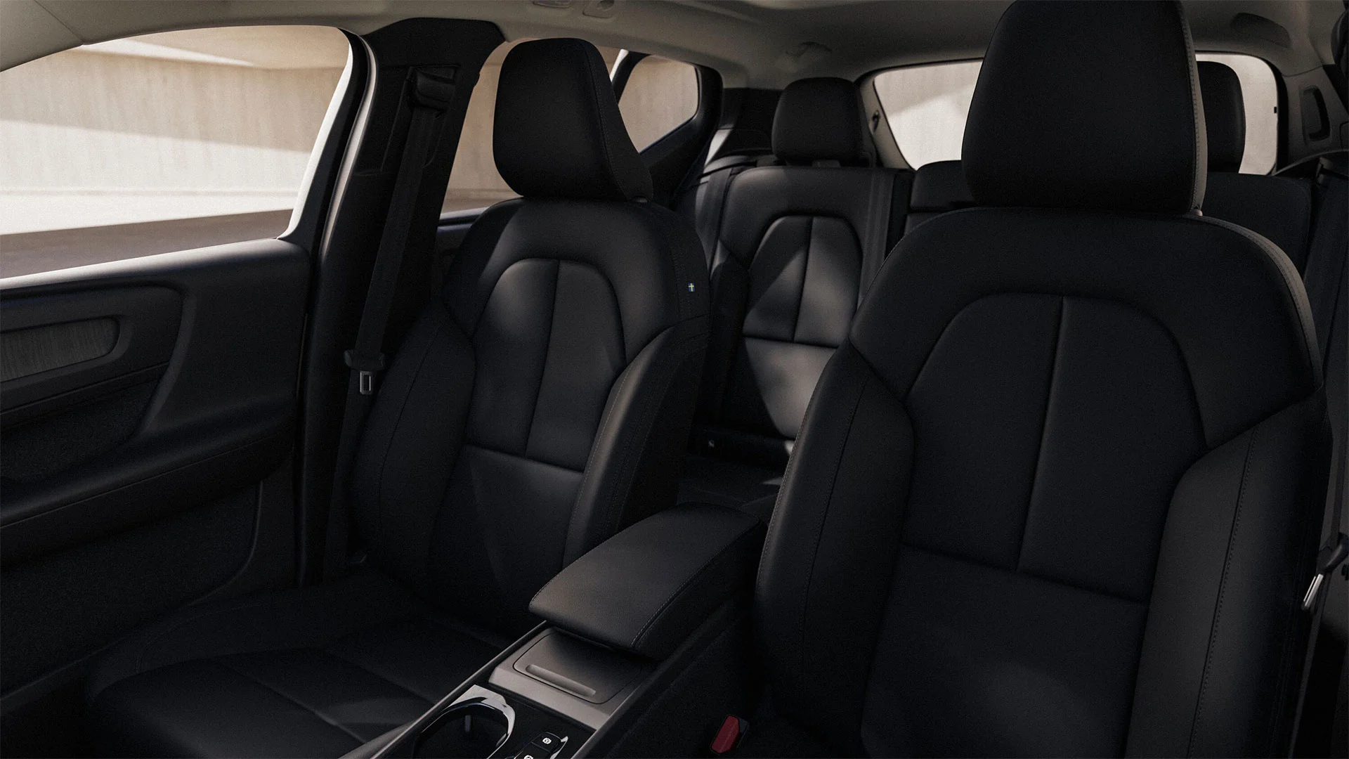 Intérieur d’une Volvo XC40 avec sièges en cuir noir, banquettes avant et arrière visibles, console centrale au premier plan