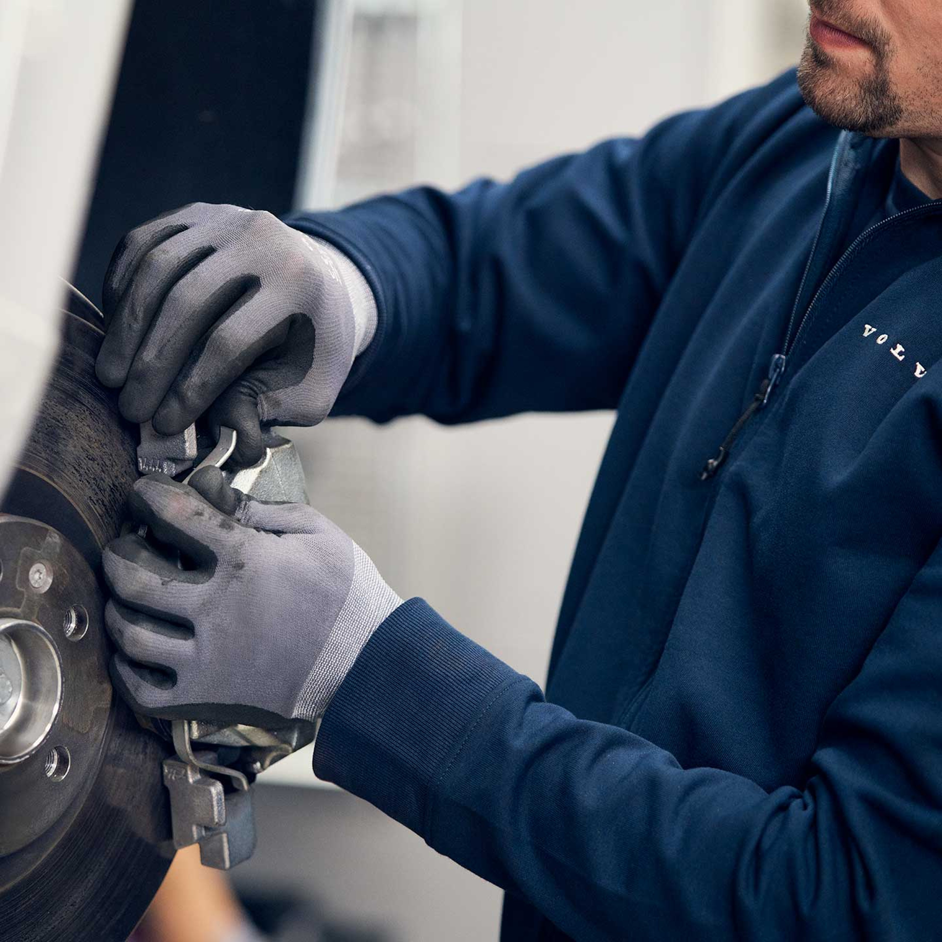 Volvo tekniker undersøger hjulet af en hvid Volvo bil