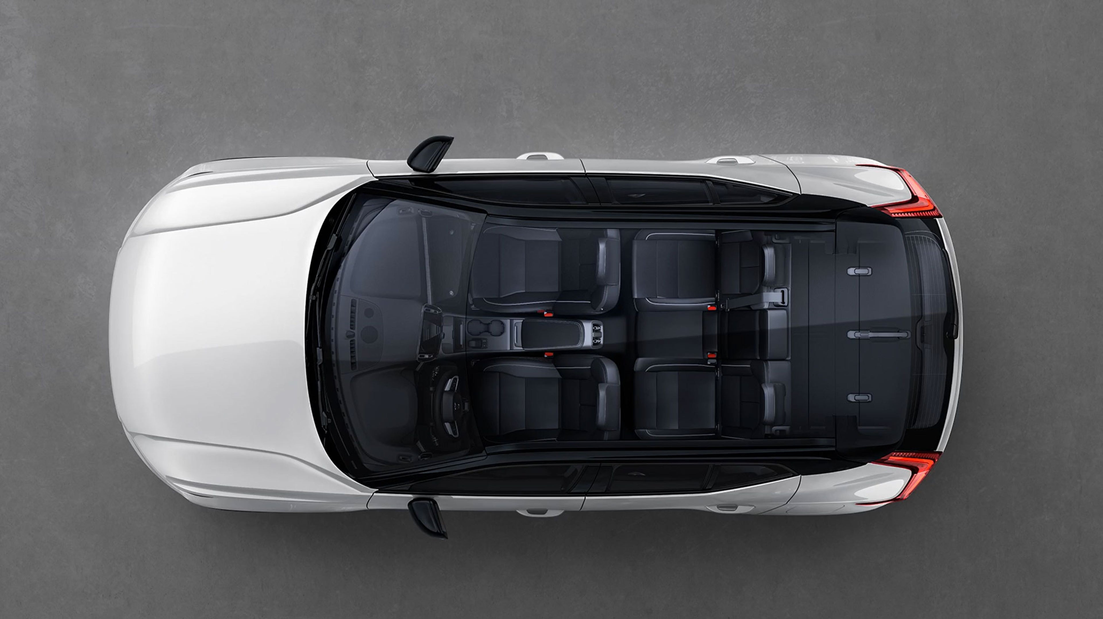 Vue aérienne d’une Volvo EX40 blanche avec toit panoramique en verre, intérieur et sièges visibles