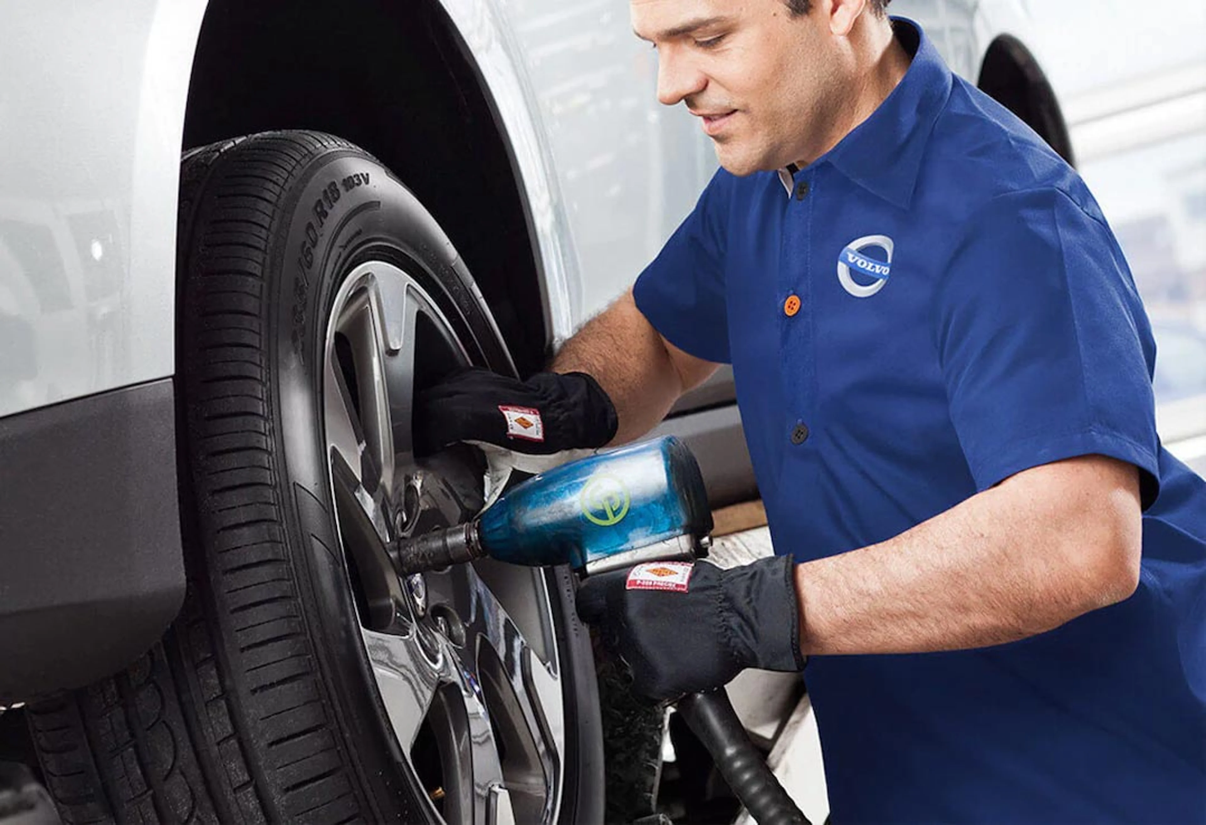 Ein Volvo Personal Service Techniker montiert ein Rad an einen Volvo, der auf einer Hebebühne steht.
