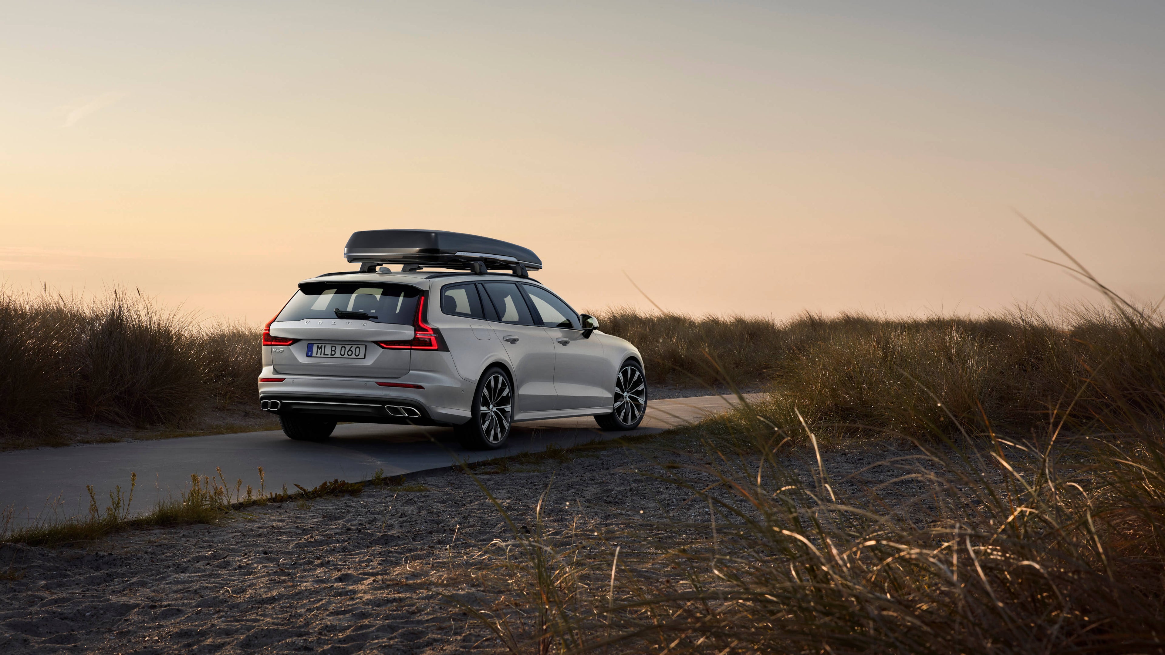 Volvo V60 mit Dachbox steht auf einem Feldweg