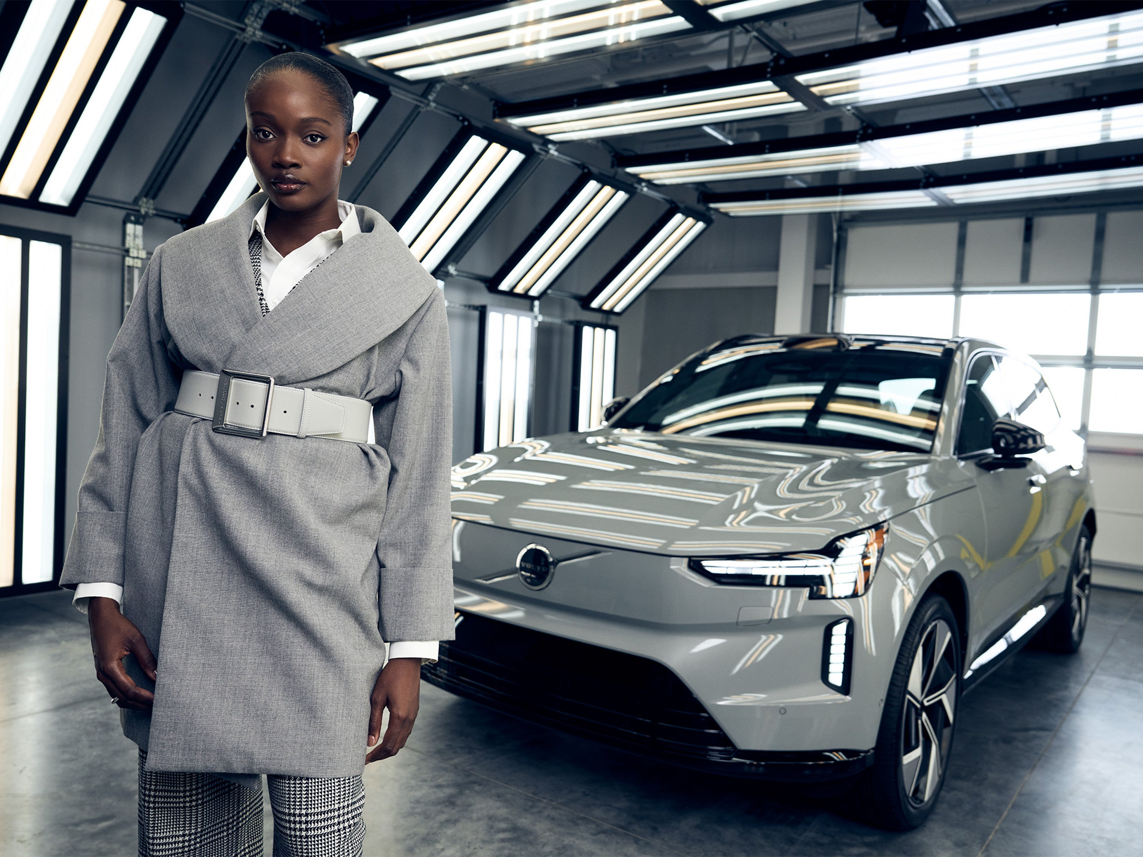 Woman wearing Sergio Hudson Car Coat next to Volvo EX90 SUV