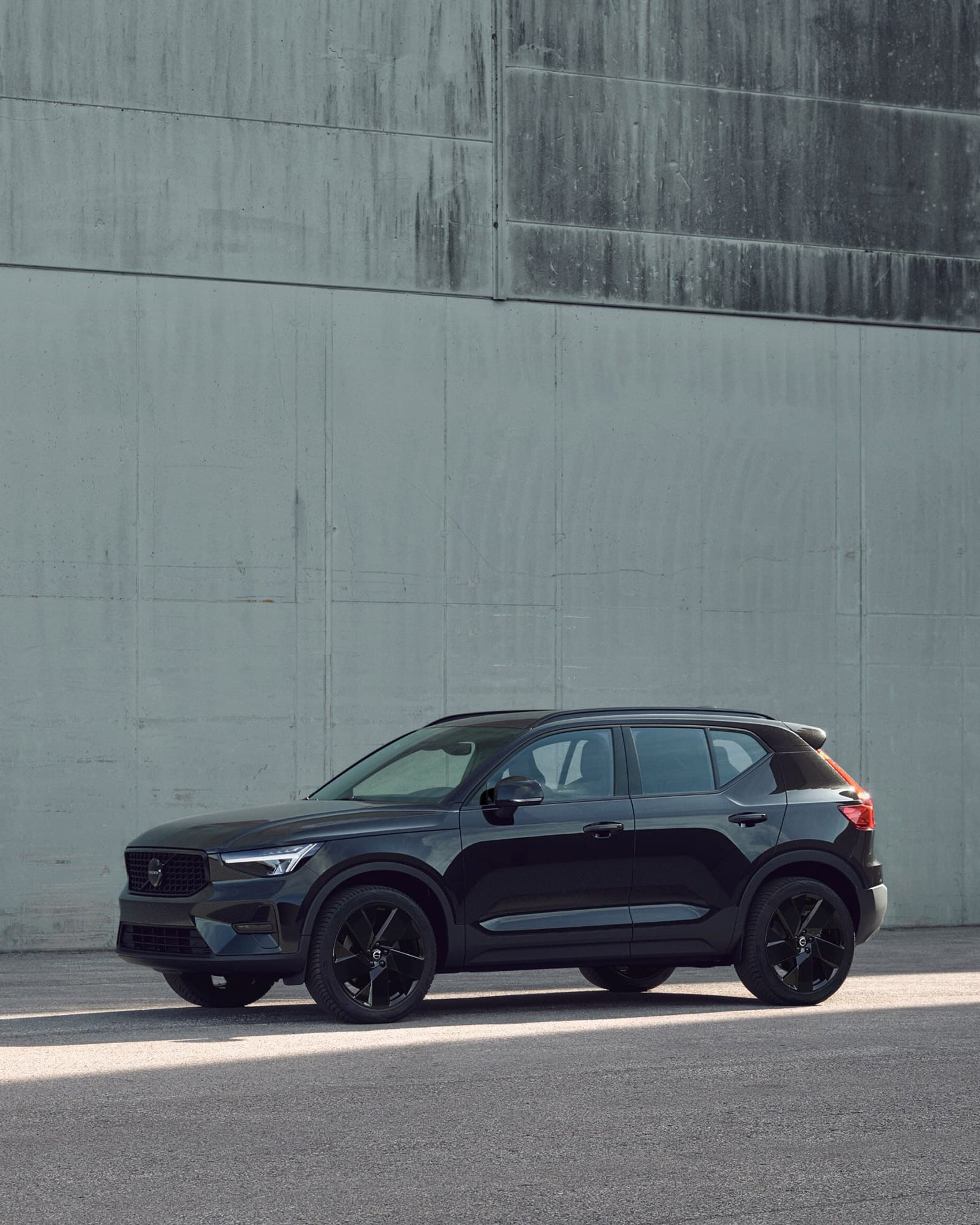 Volvo XC40 garée contre un mur vert