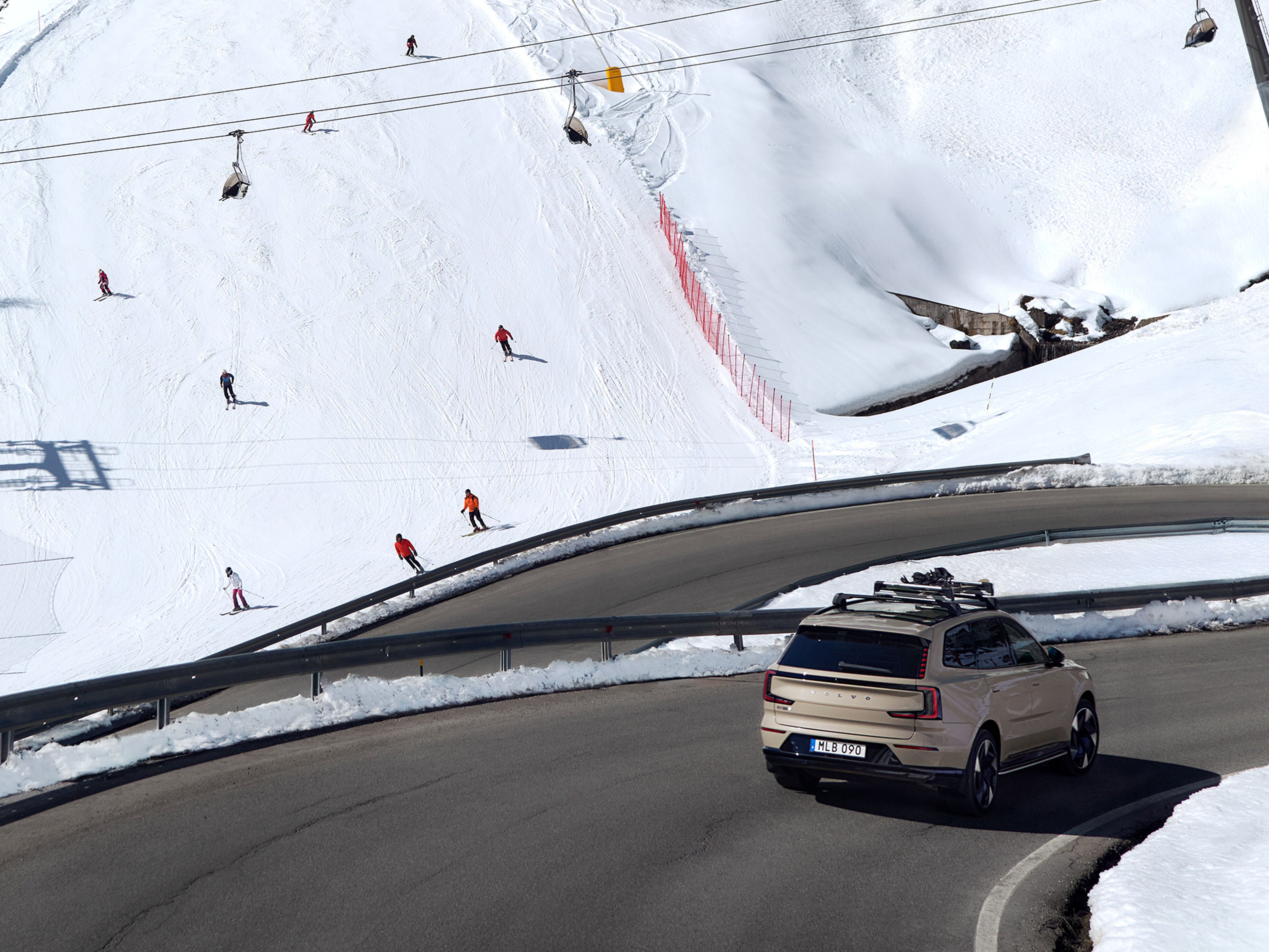 Ein Volvo EX90 fährt neben einer Ski Piste