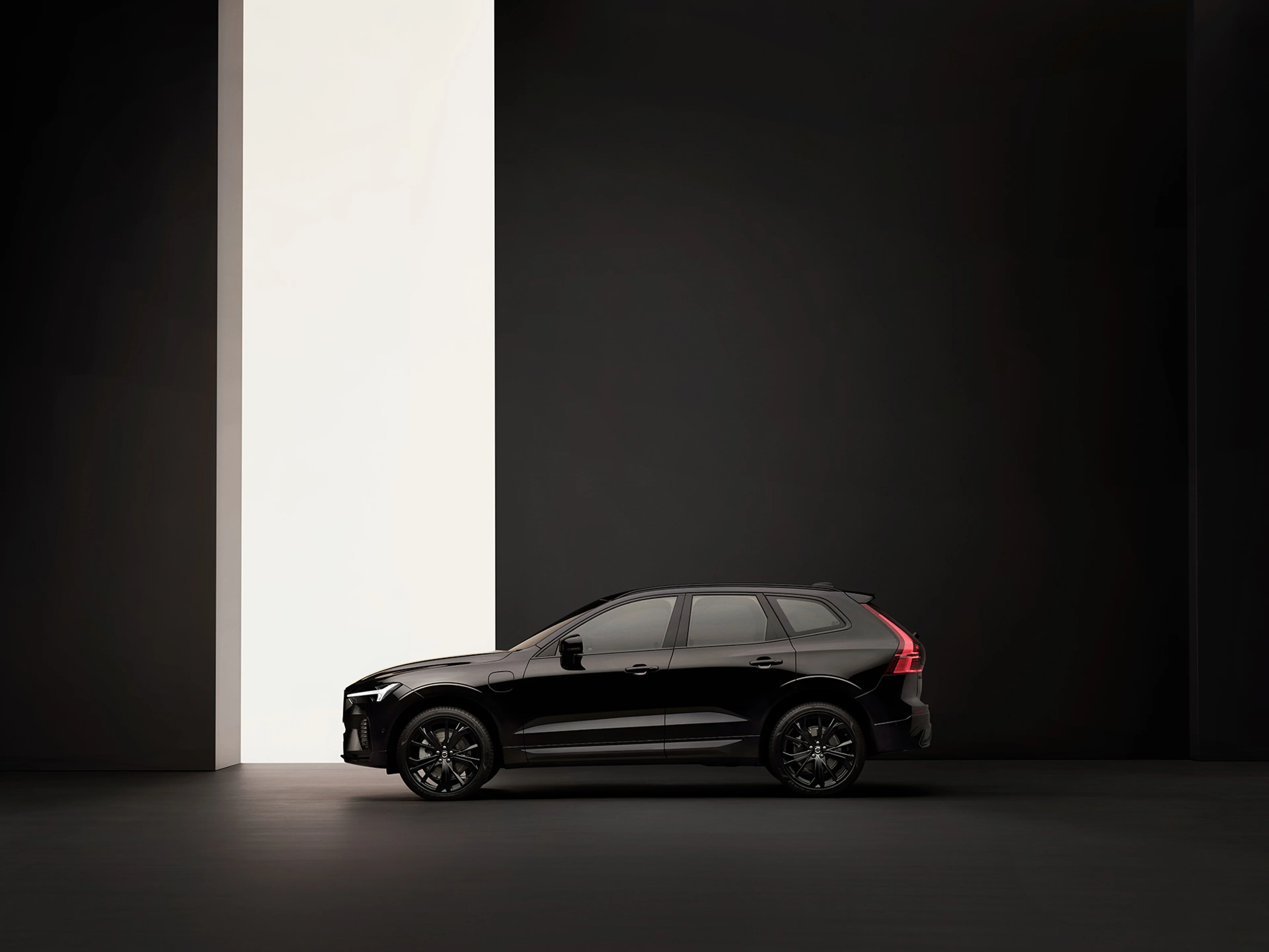 XC60 black edition de perfil, num estudio preto com uma abertura lateral