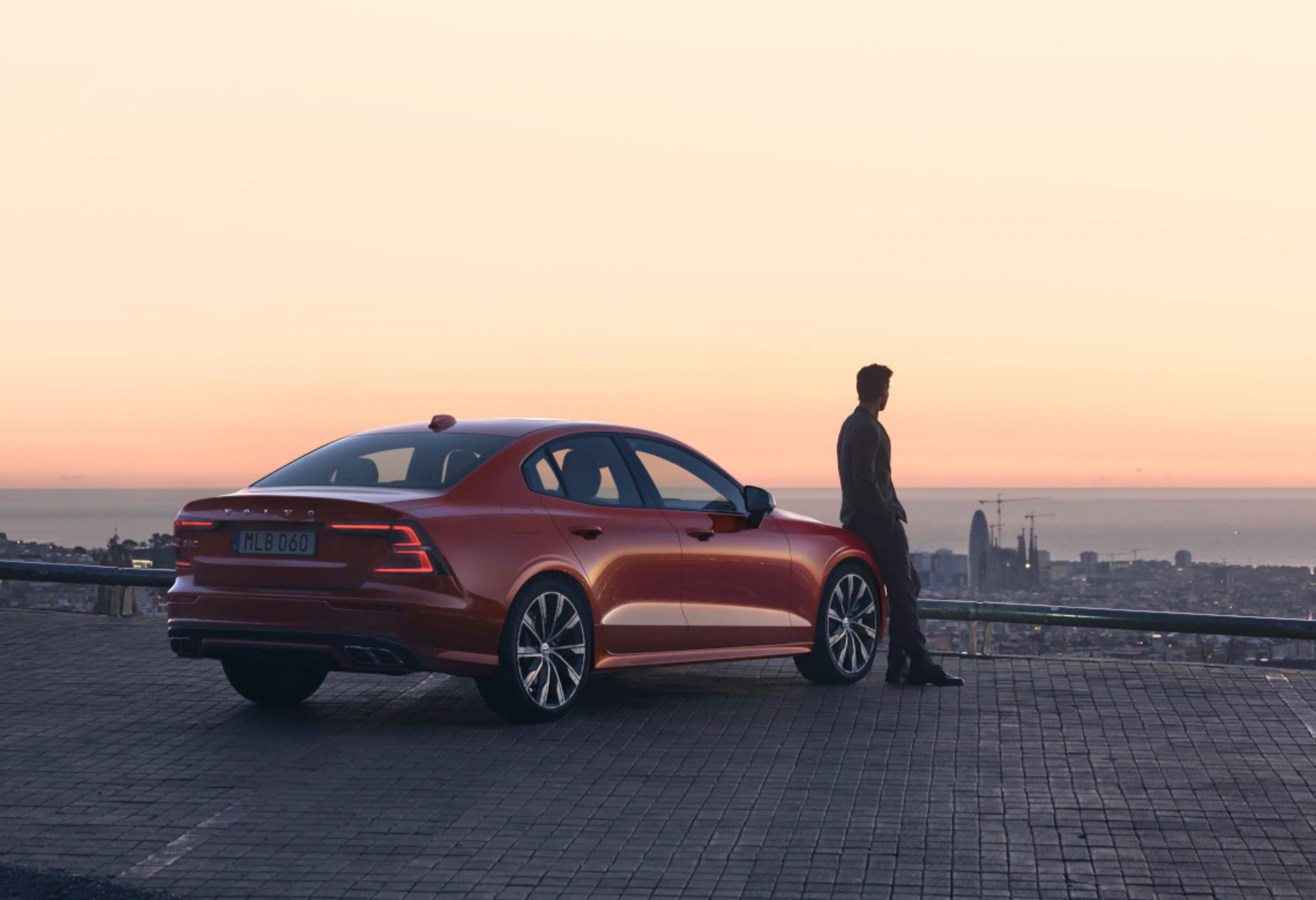 Mann lehnt an Volvo S60 R-DESIGN bei Sonnenuntergang