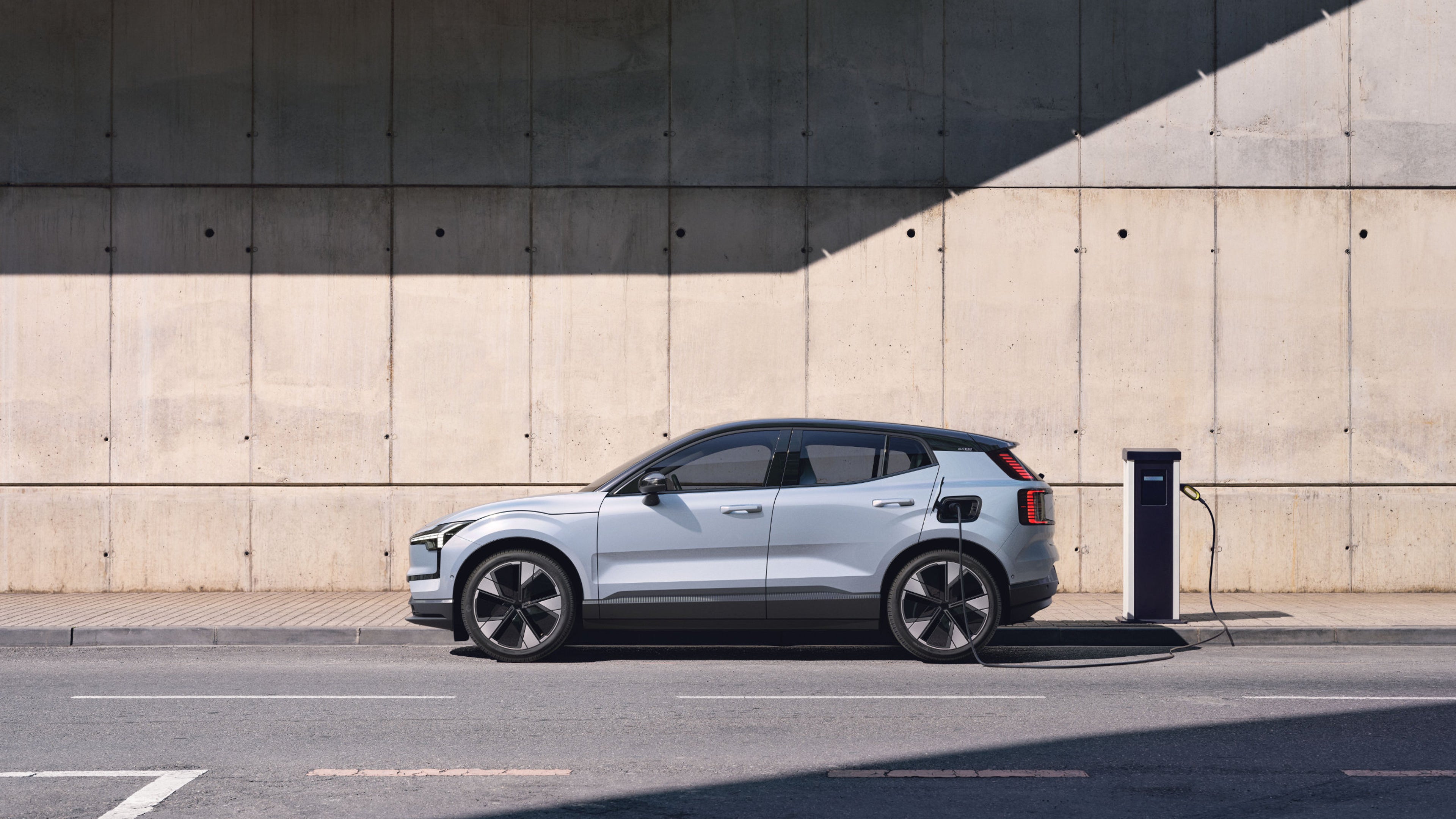 Seitenansicht eines weißen Volvo EX30 mit schwarzem Dach.