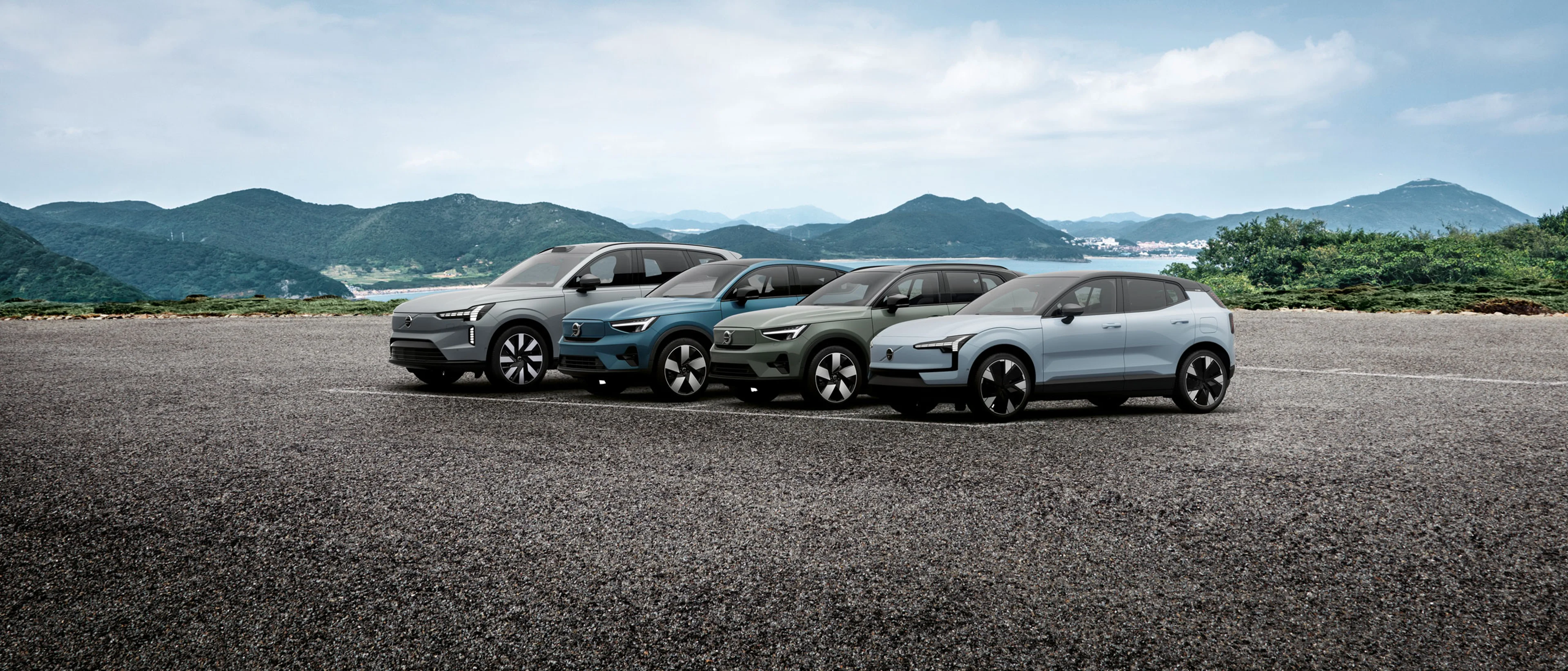 3 Volvo alignés avec des montagnes en second plan