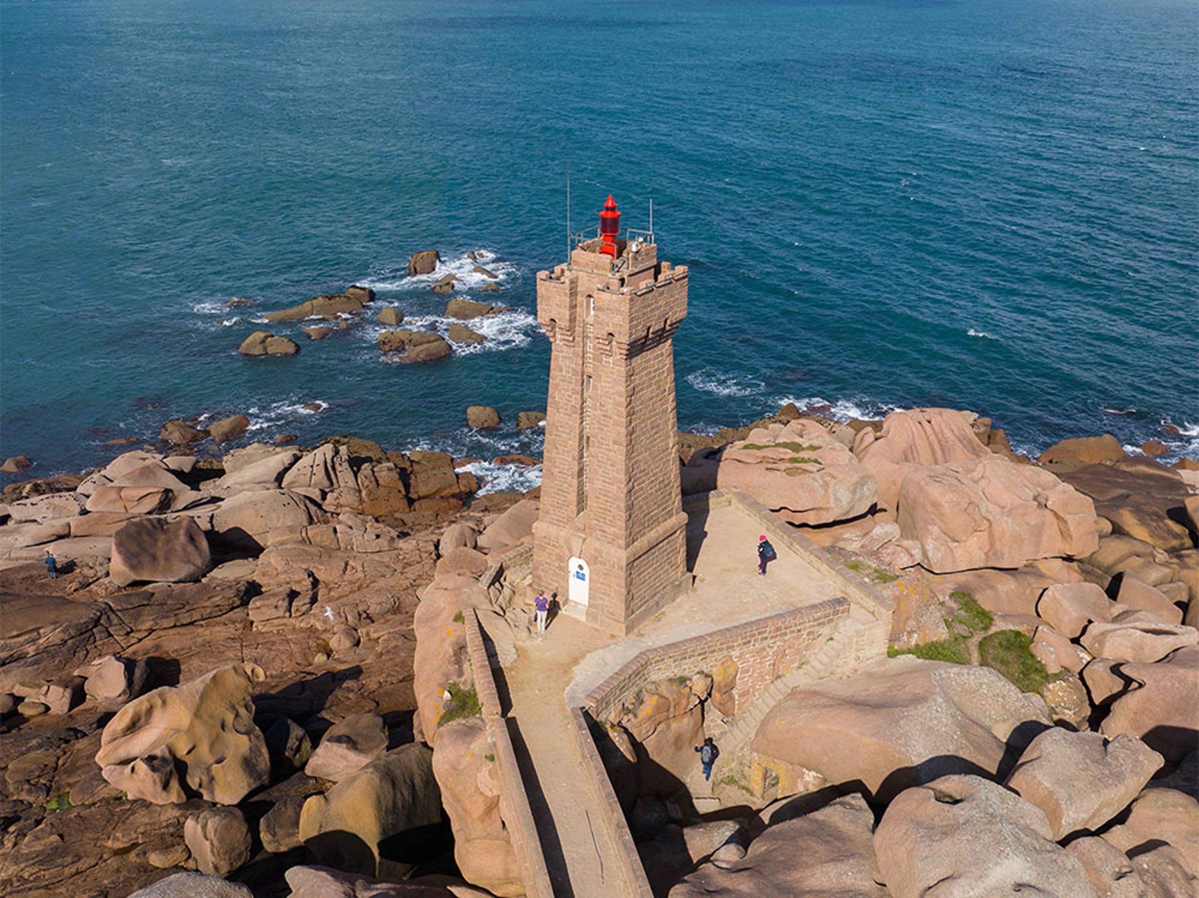Vue aérienne d’un phare sur une côte rocheuse avec l’océan en arrière-plan