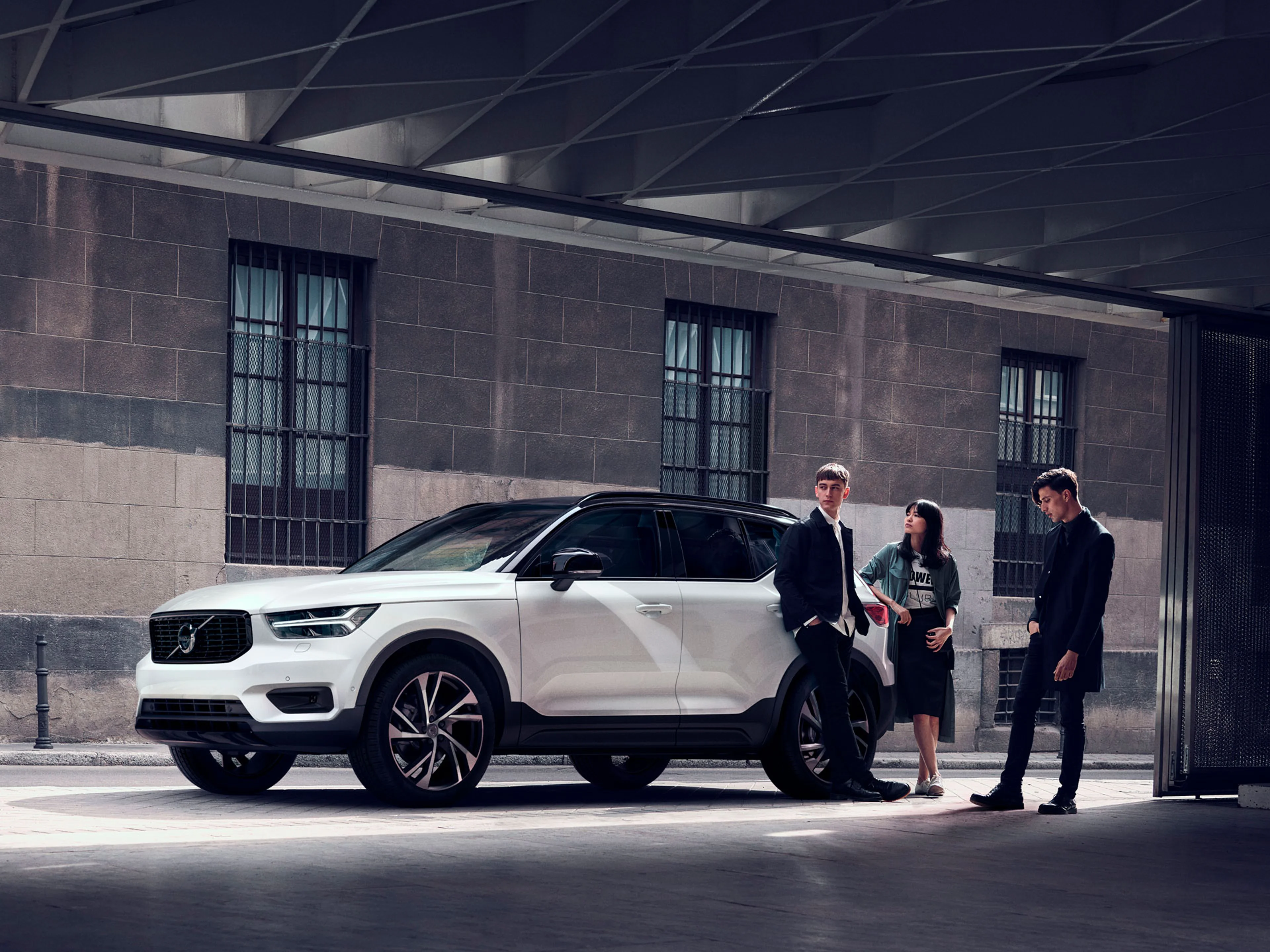 Un grupo de personas a un lado de un Volvo XC40 estacionado