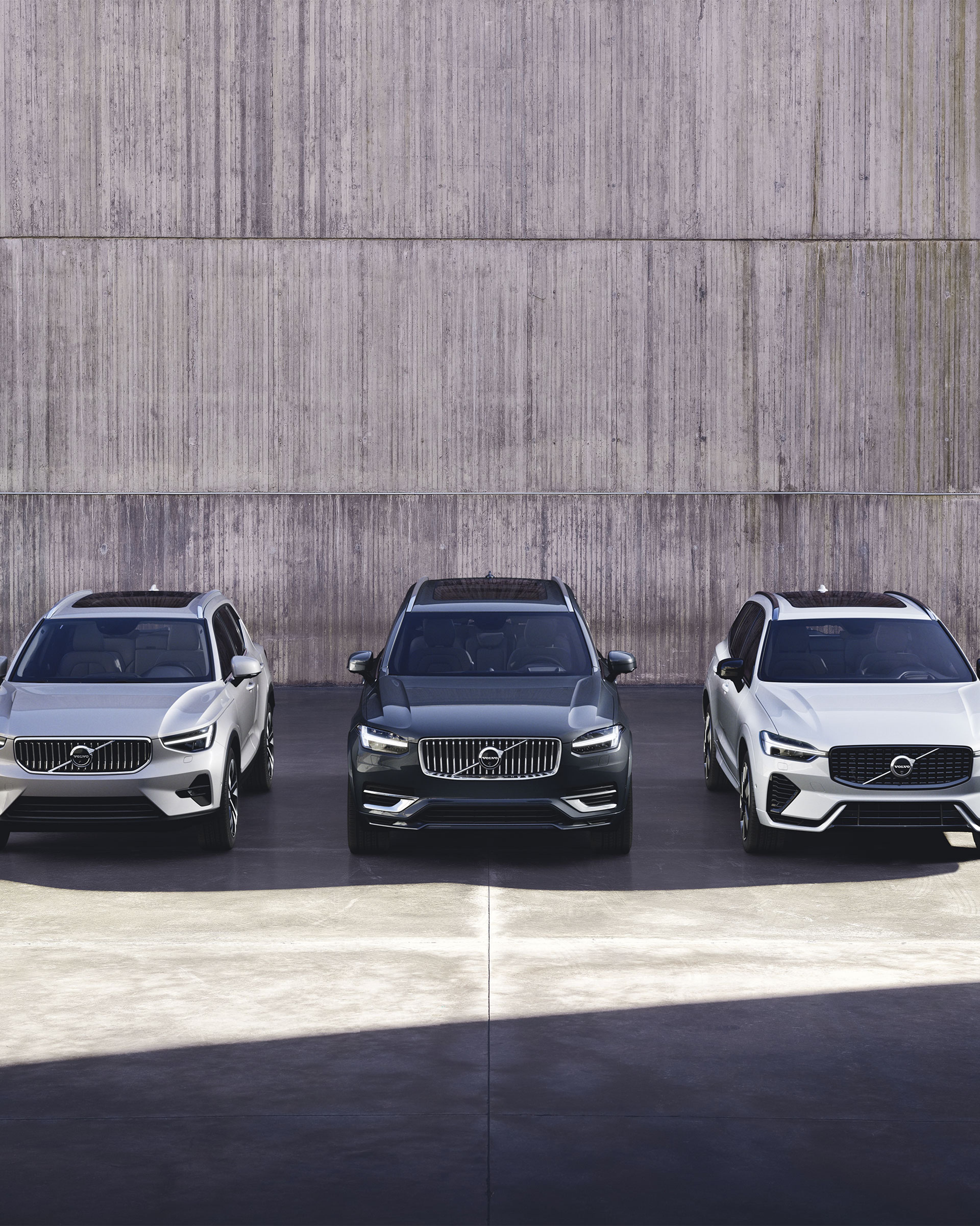 Trois Volvo XC60 garées devant un mur en béton