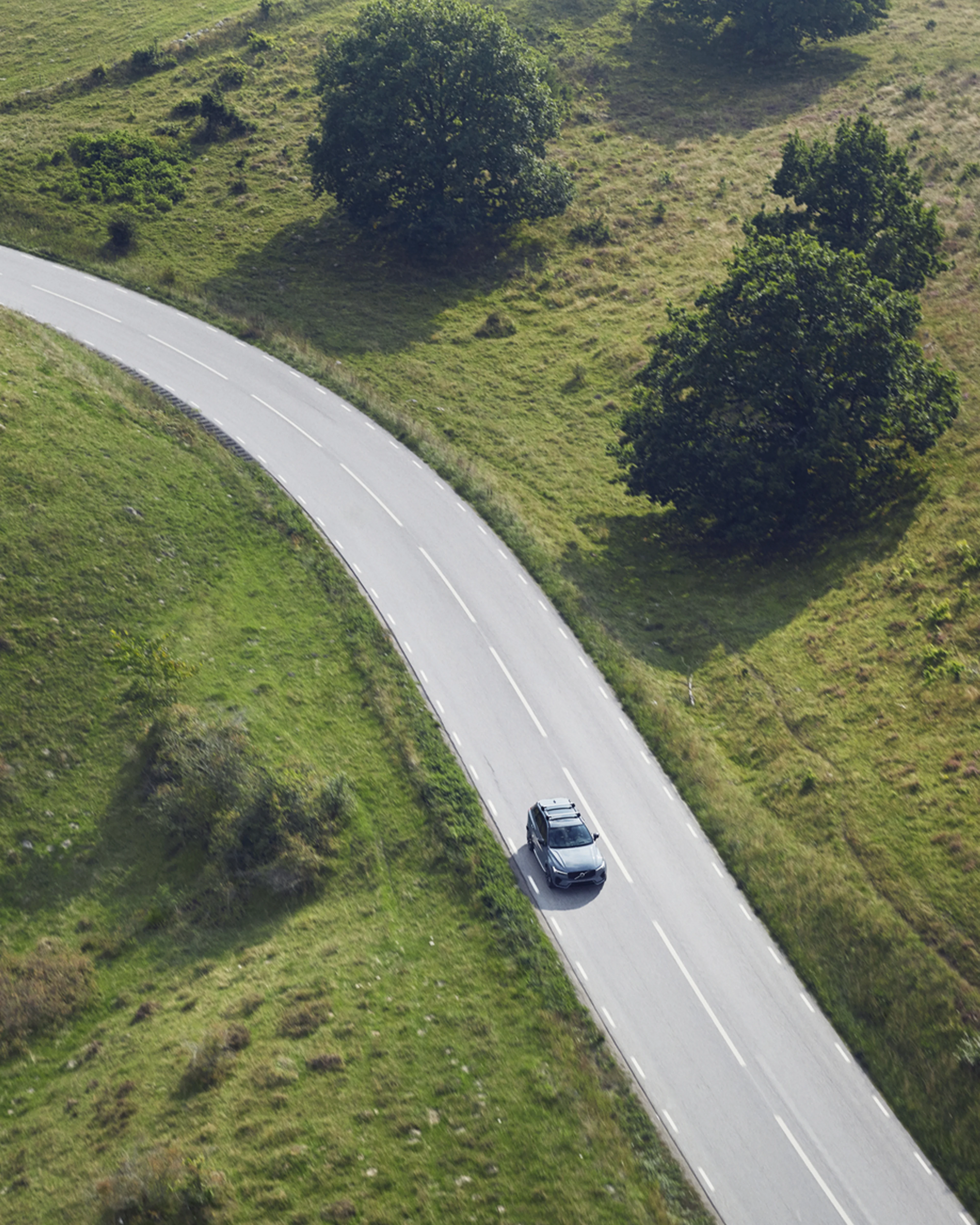 Un vehículo Volvo sobre una carretera con páramos verdes a los costados.
