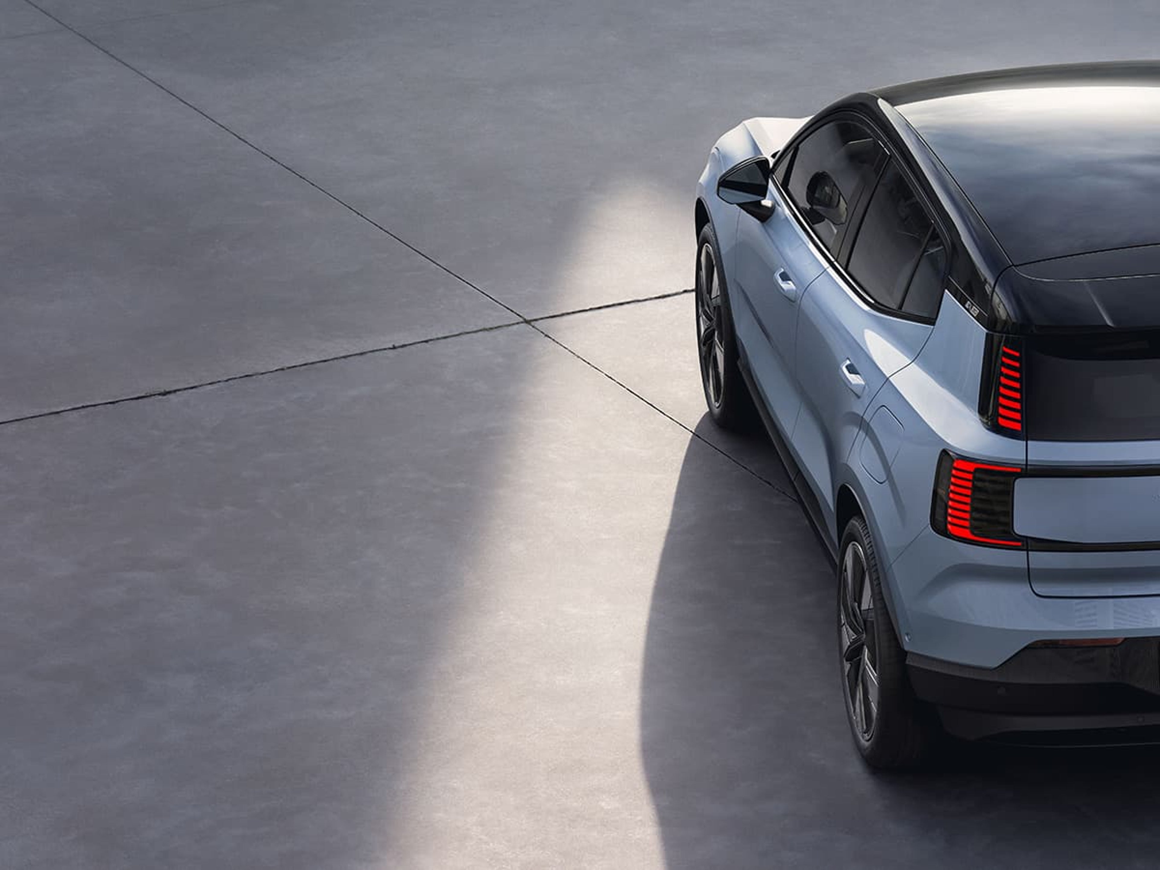 Achterkant van een Volvo EX30 op een betonnen vloer.