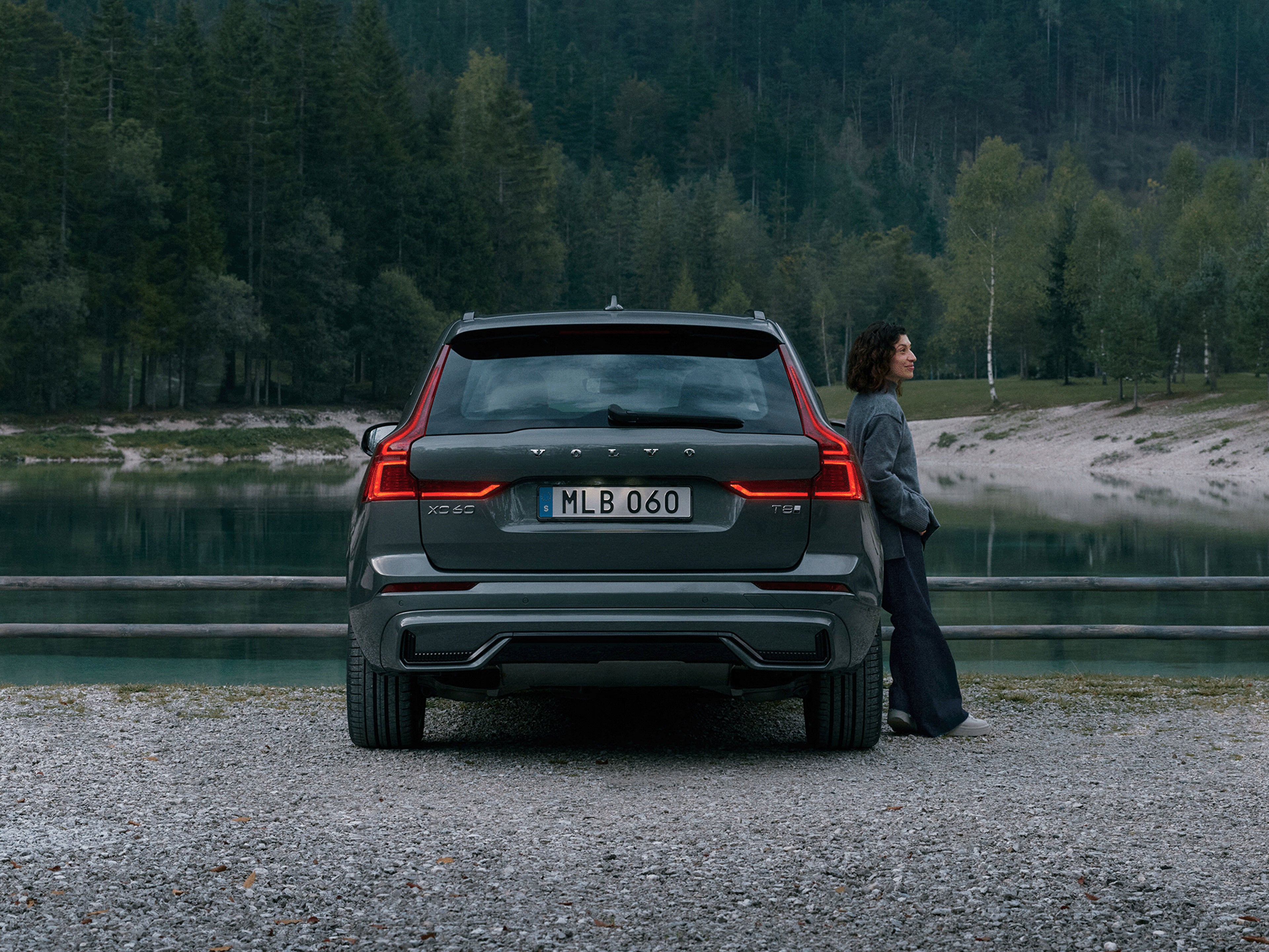 Eine Frau lehnt an einem Volvo XC60.