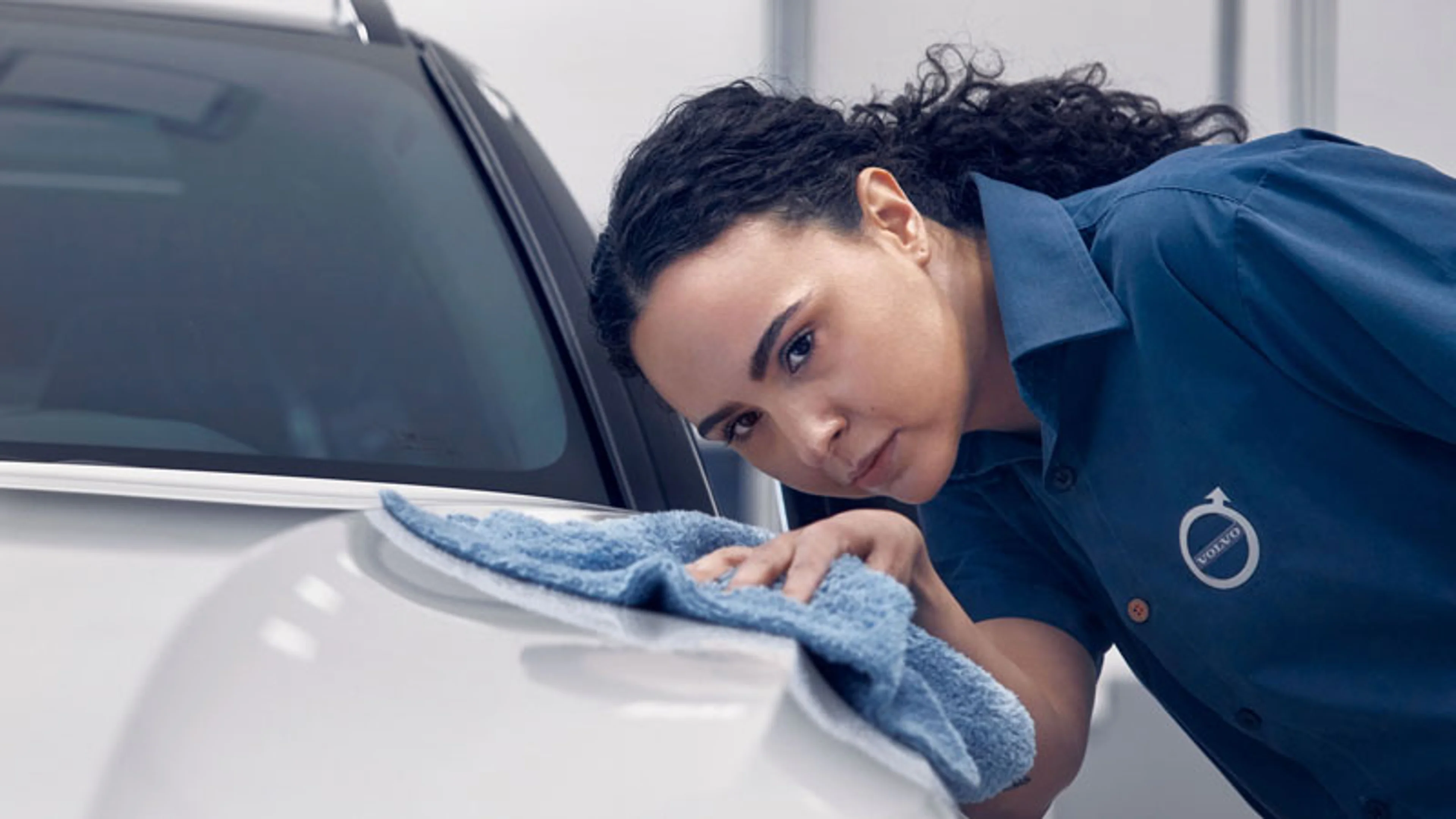 Femme nettoyant le capot d'une Volvo
