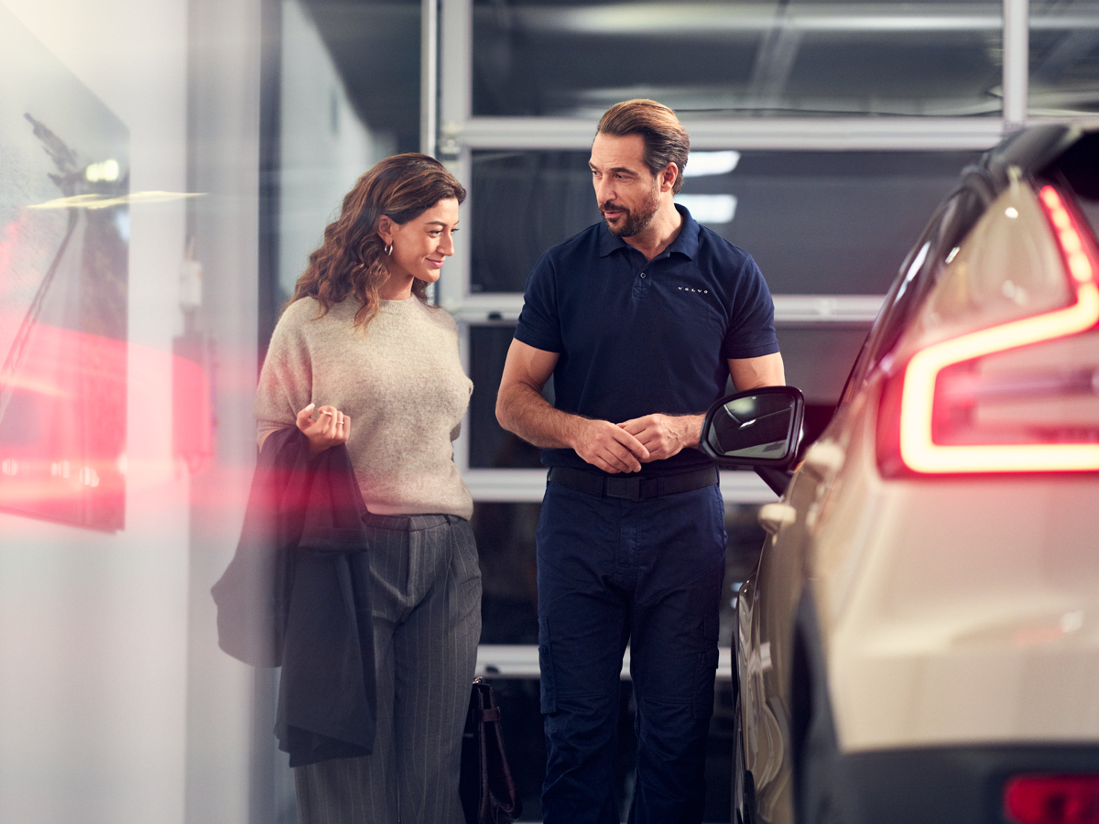 Volvo servicetekniker diskuterar med kund vid en Volvo EC40