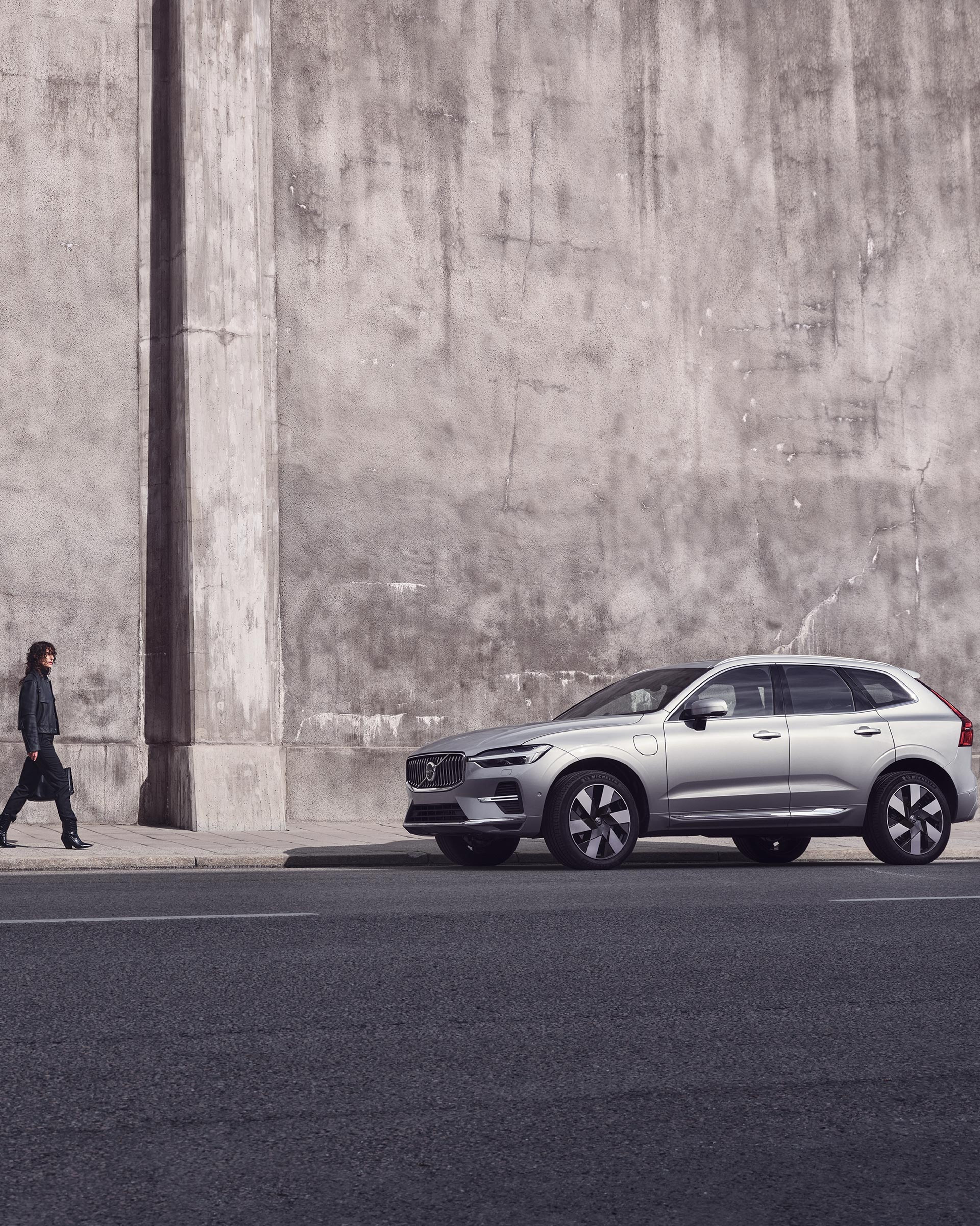 Eine Frau mit einer Tasche in der Hand geht auf einen XC60 zu.