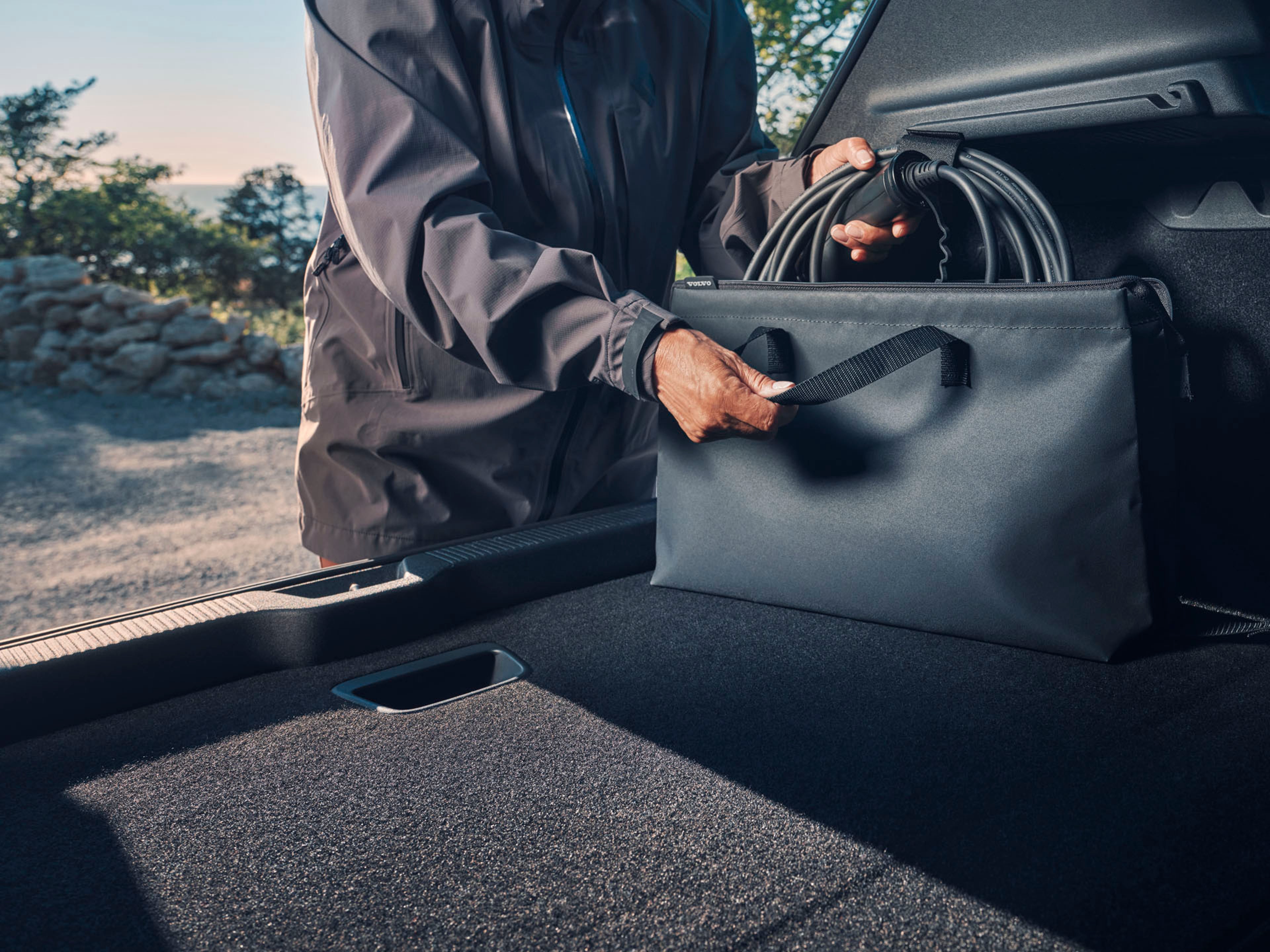 Un hombre poniendo un accesorio Volvo en la zona de carga del vehículo