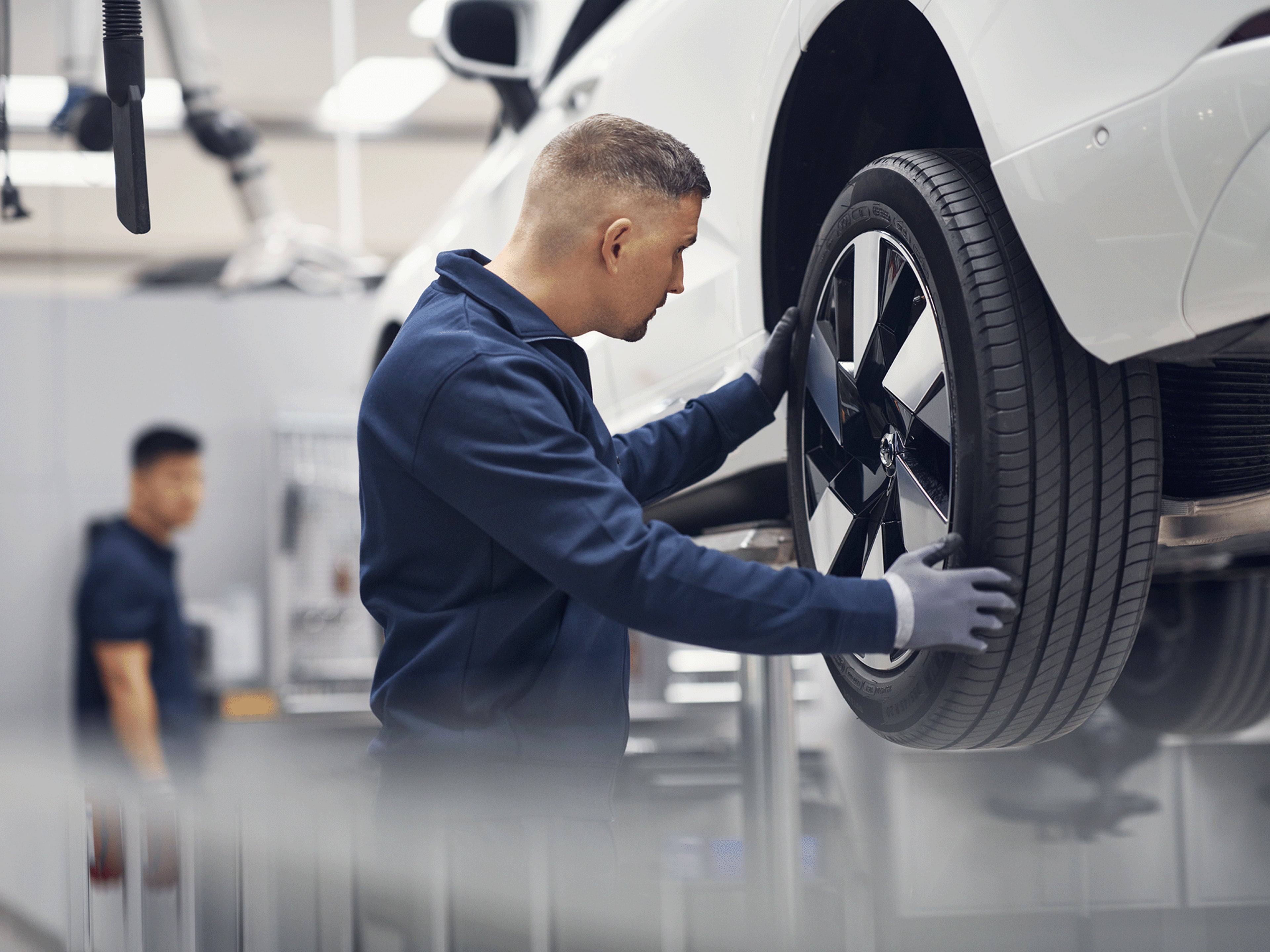 Ein Volvo Mitarbeitender arbeitet an einem Volvo in einer Werkstatt.