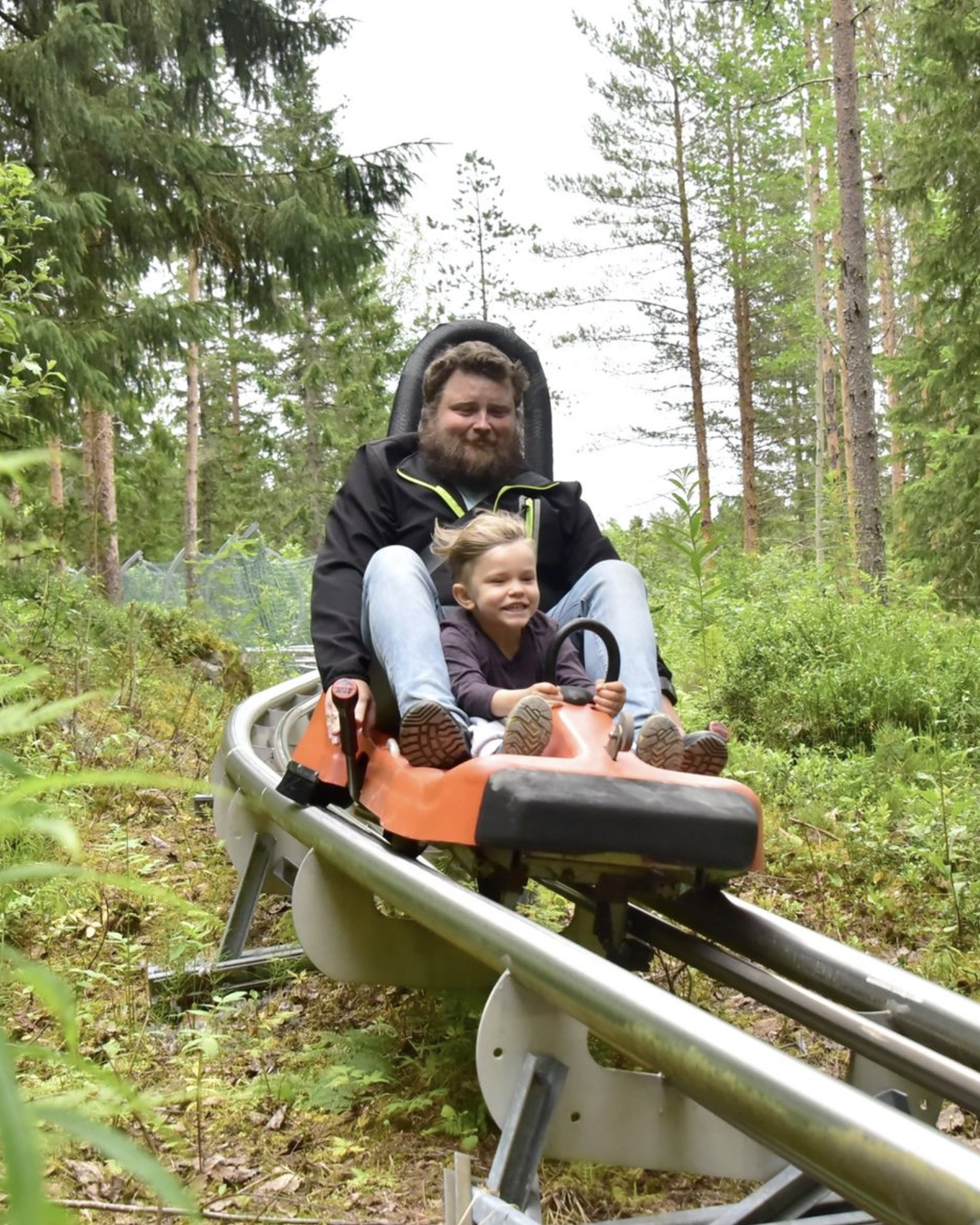 Mann og barn kjørende med banen