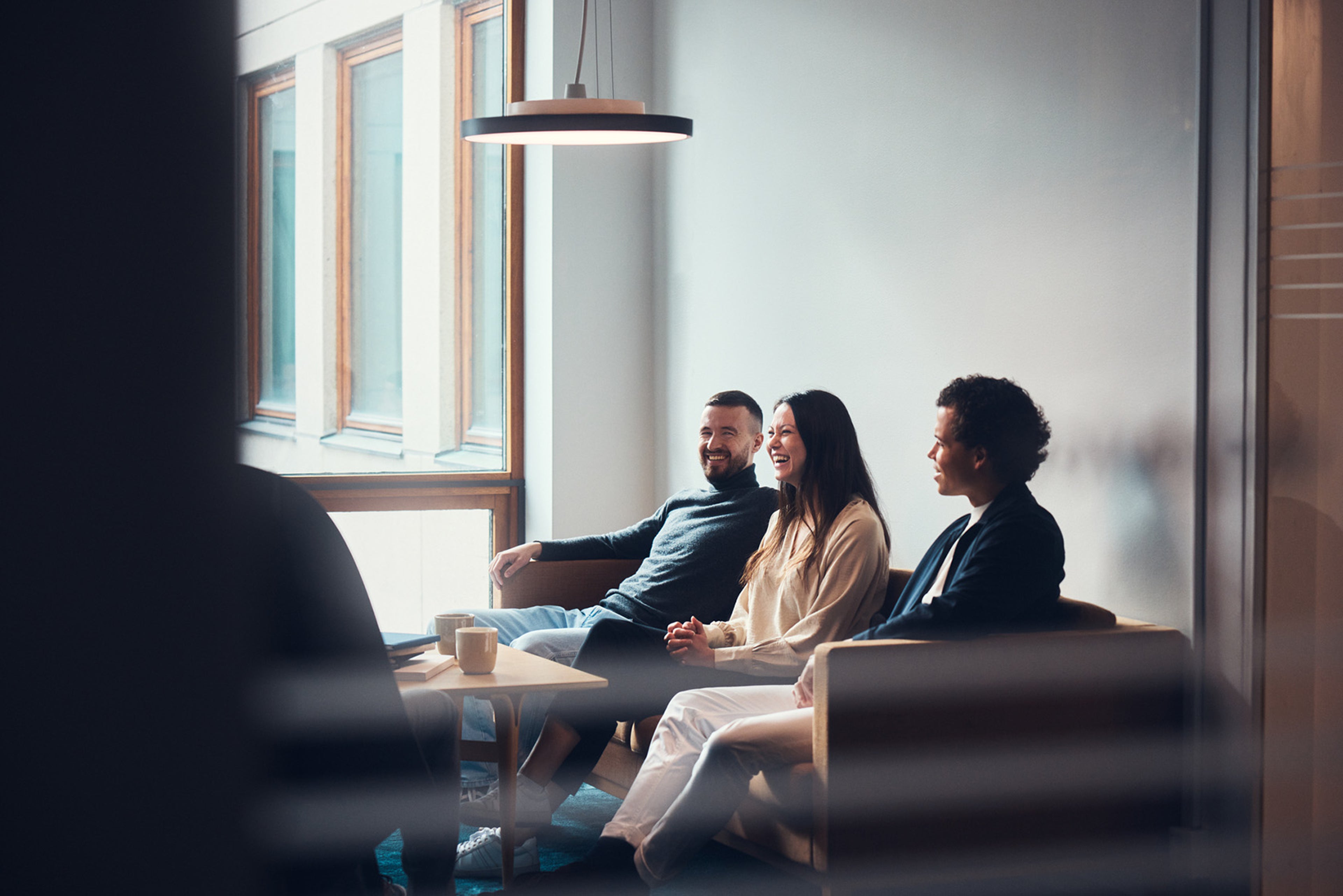 A woman in a pink jacket smiling at someone or something