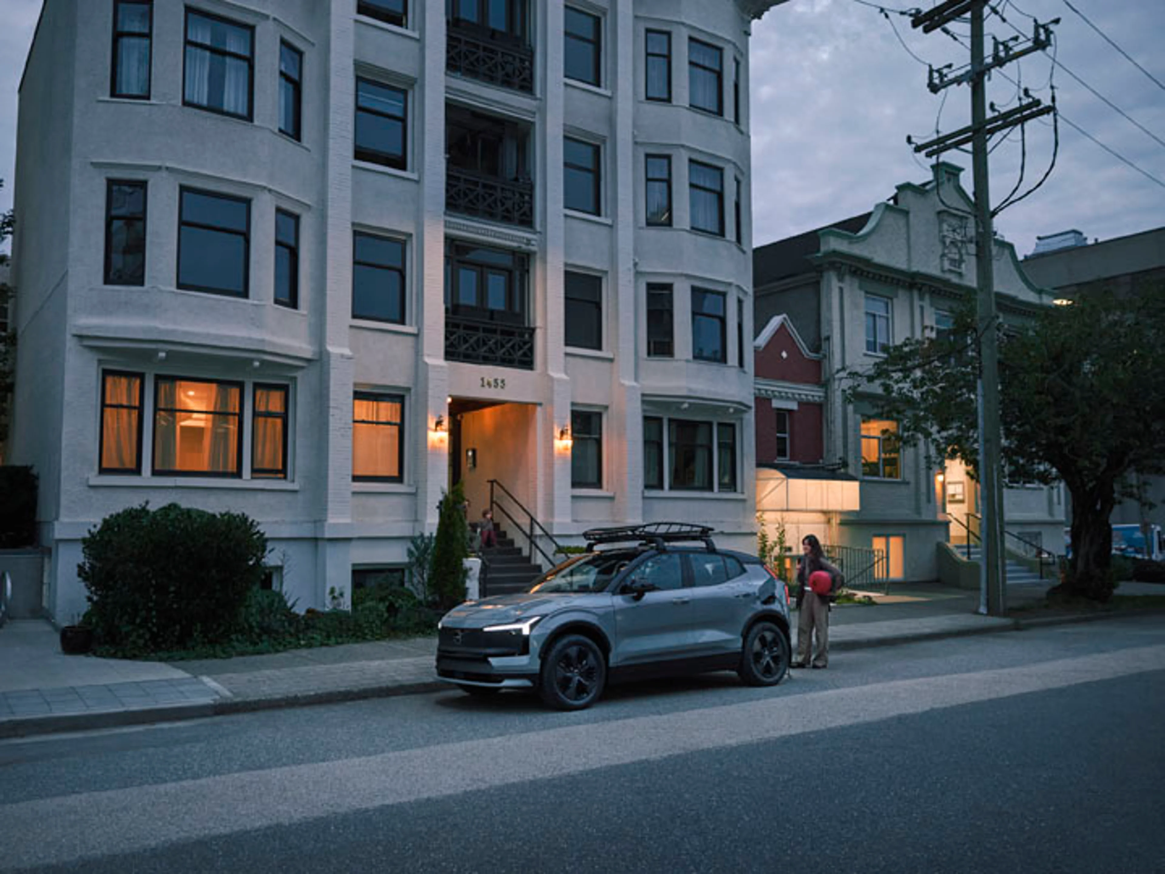 Un Volvo EX30 eléctrico a la salida de una casa de varios pisos