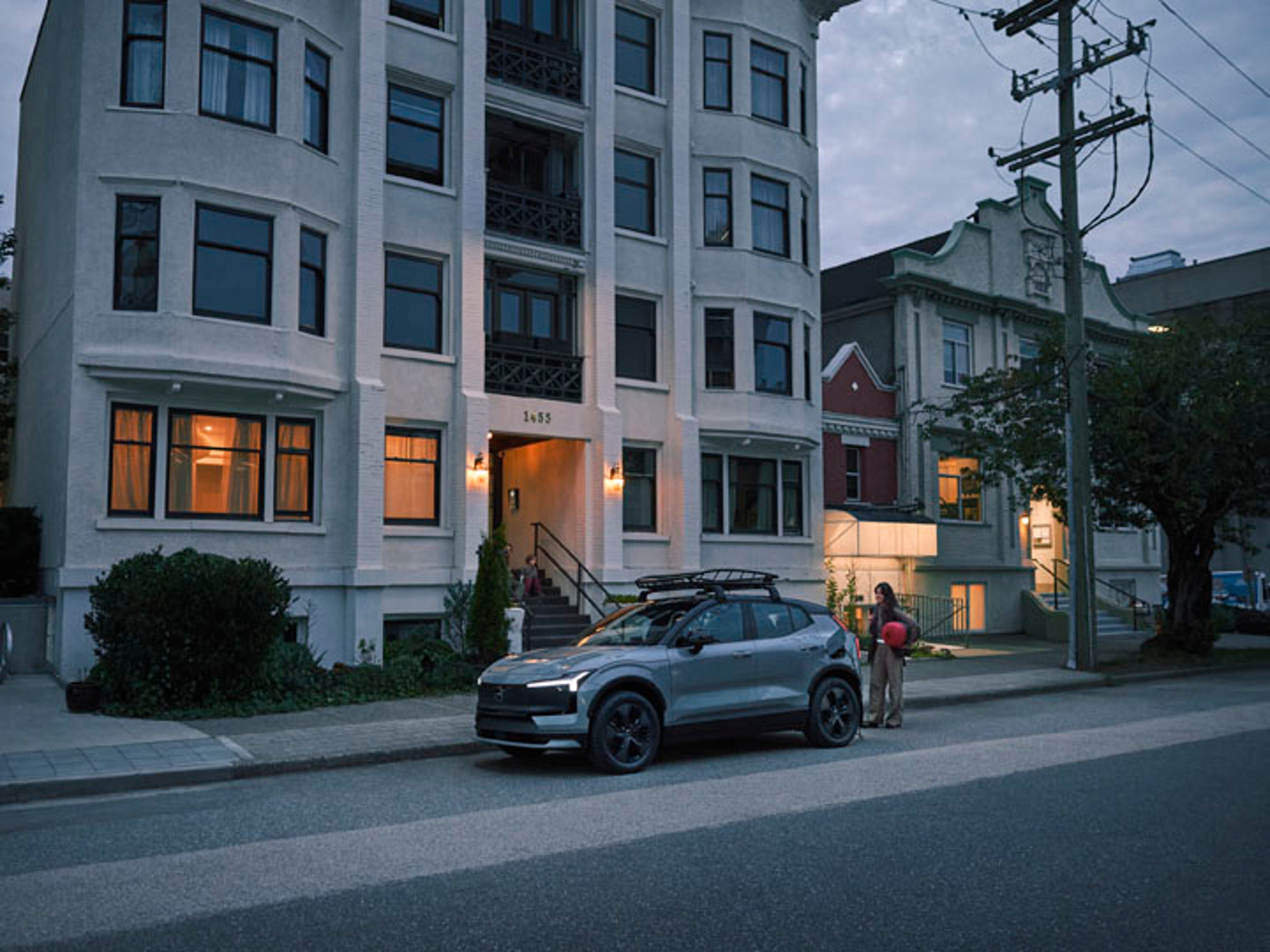 Un Volvo EX30 eléctrico a la salida de una casa de varios pisos