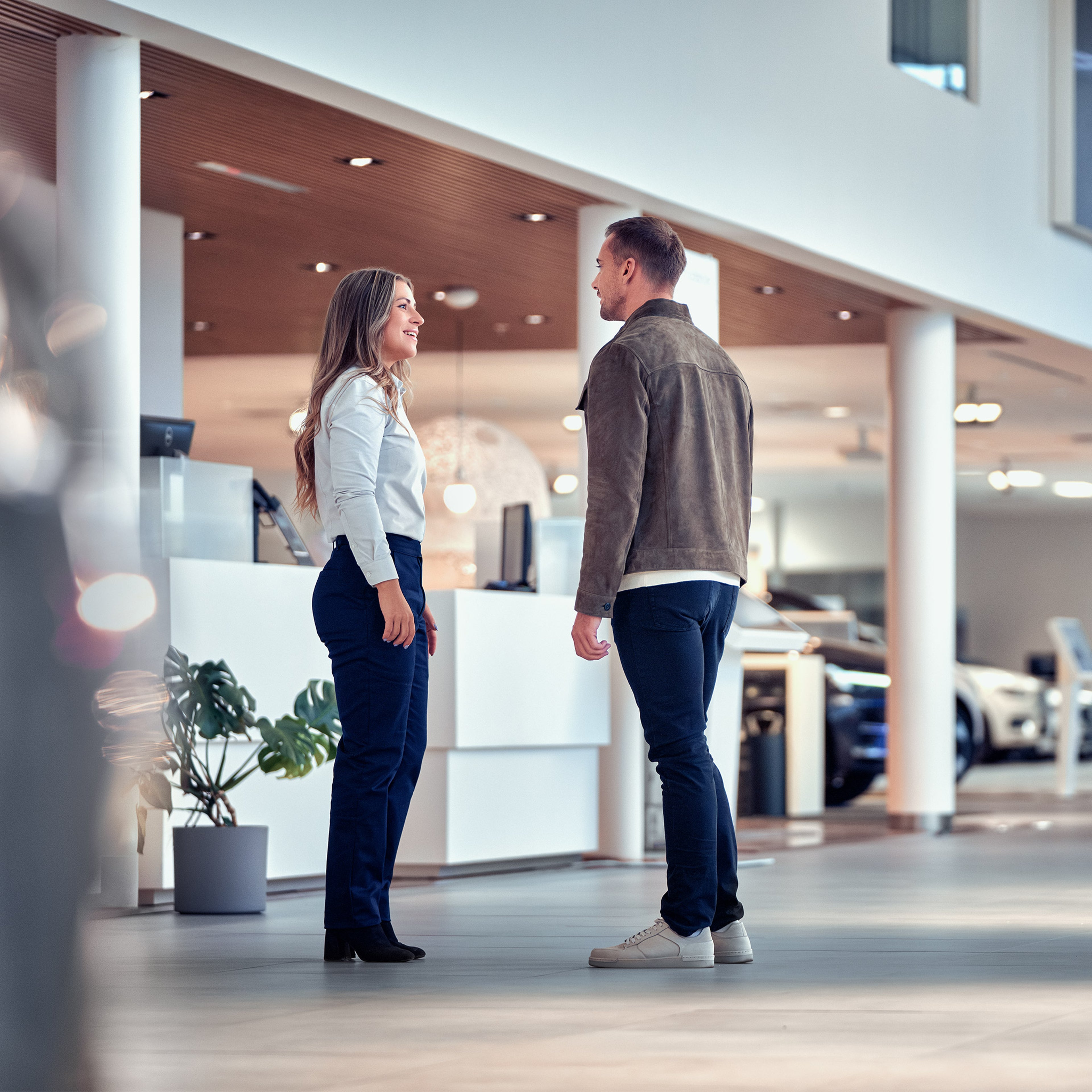 Volvon työntekijä keskustelee asiakkaan kanssa Volvon liikkeessä.