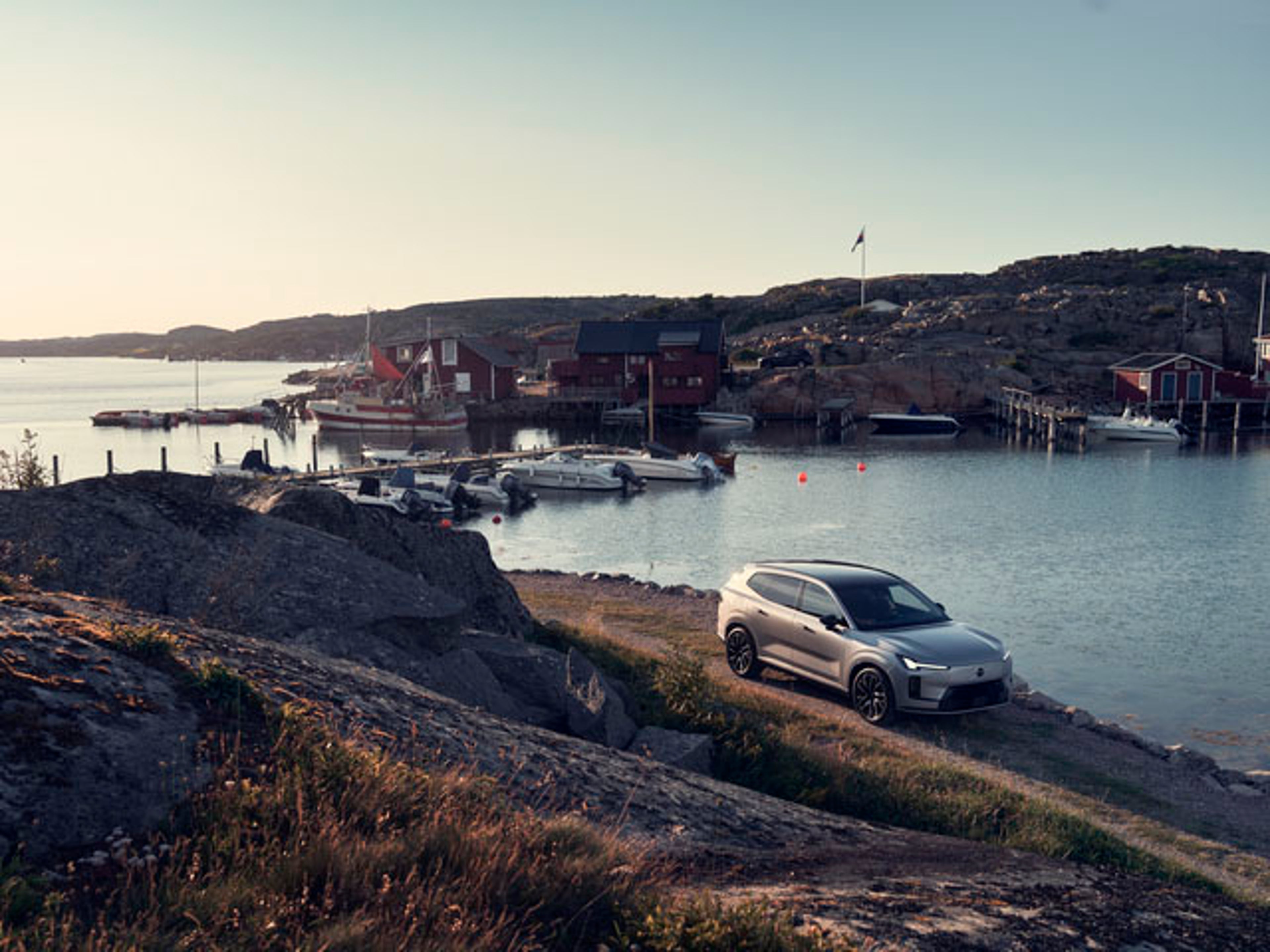 Un vehículo Volvo EX90 pasando junto a un puerto de mar