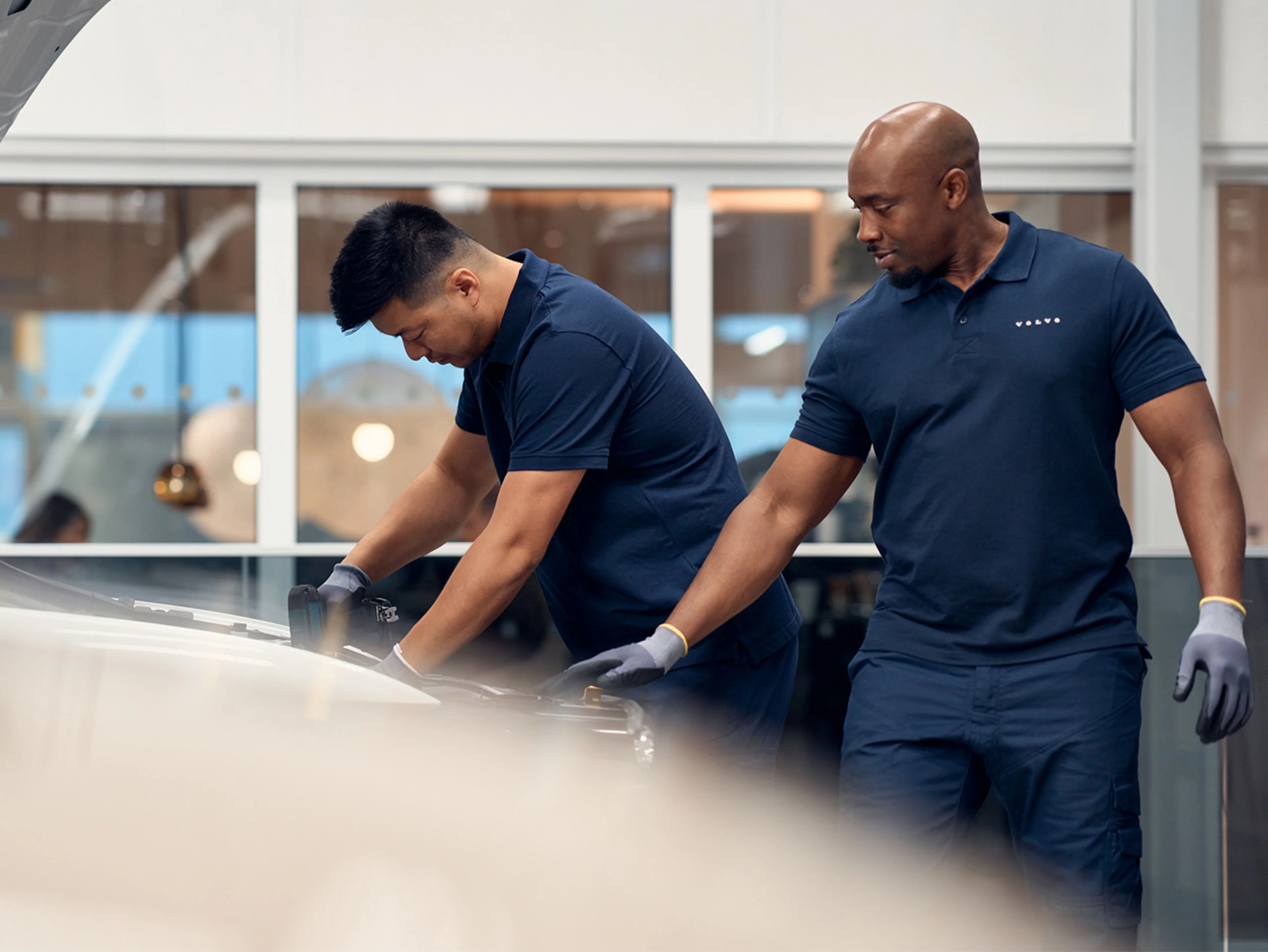 Two Volvo technicians working in a Volvo workshop.