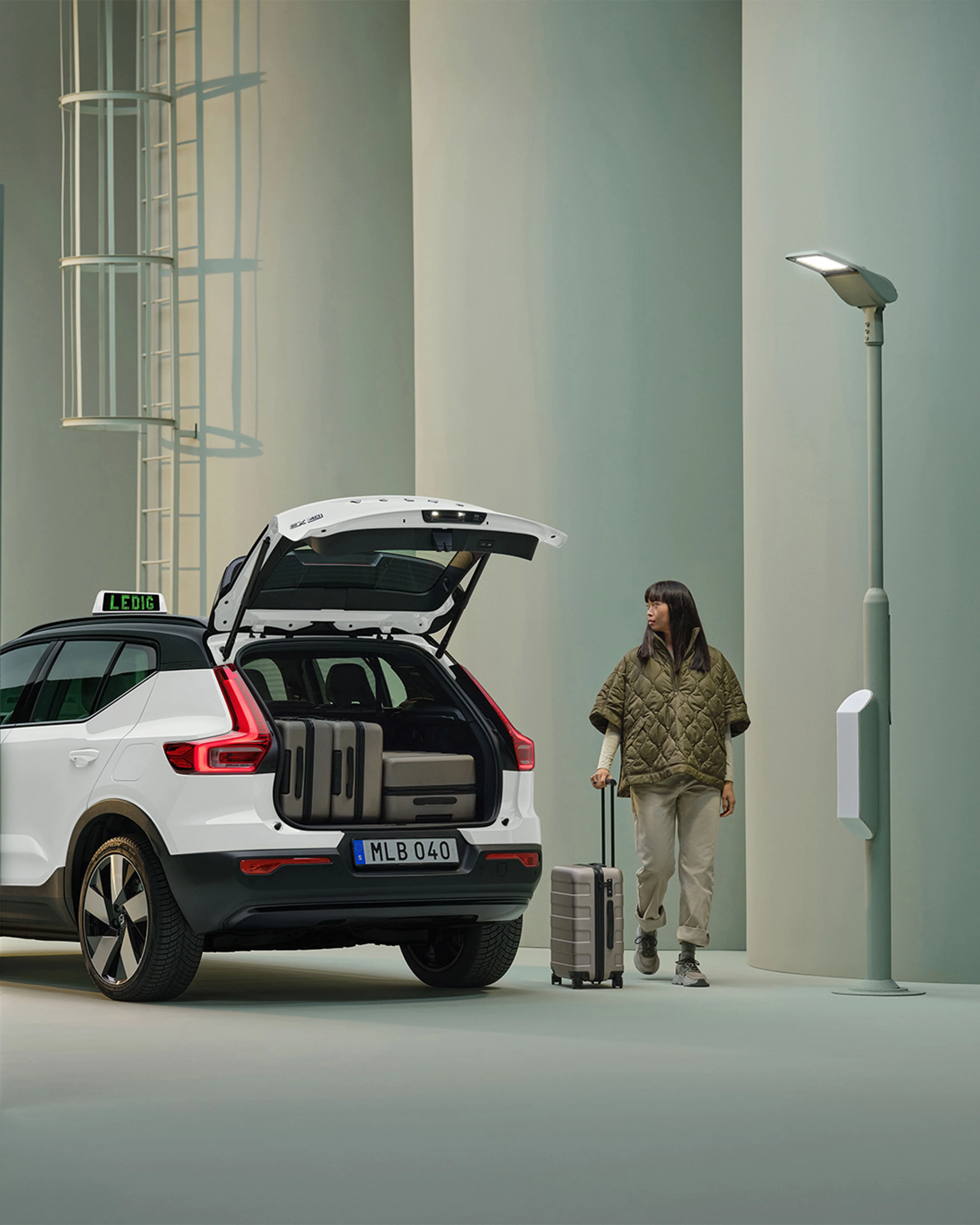 Kvinna står bredvid vit Volvo EX40