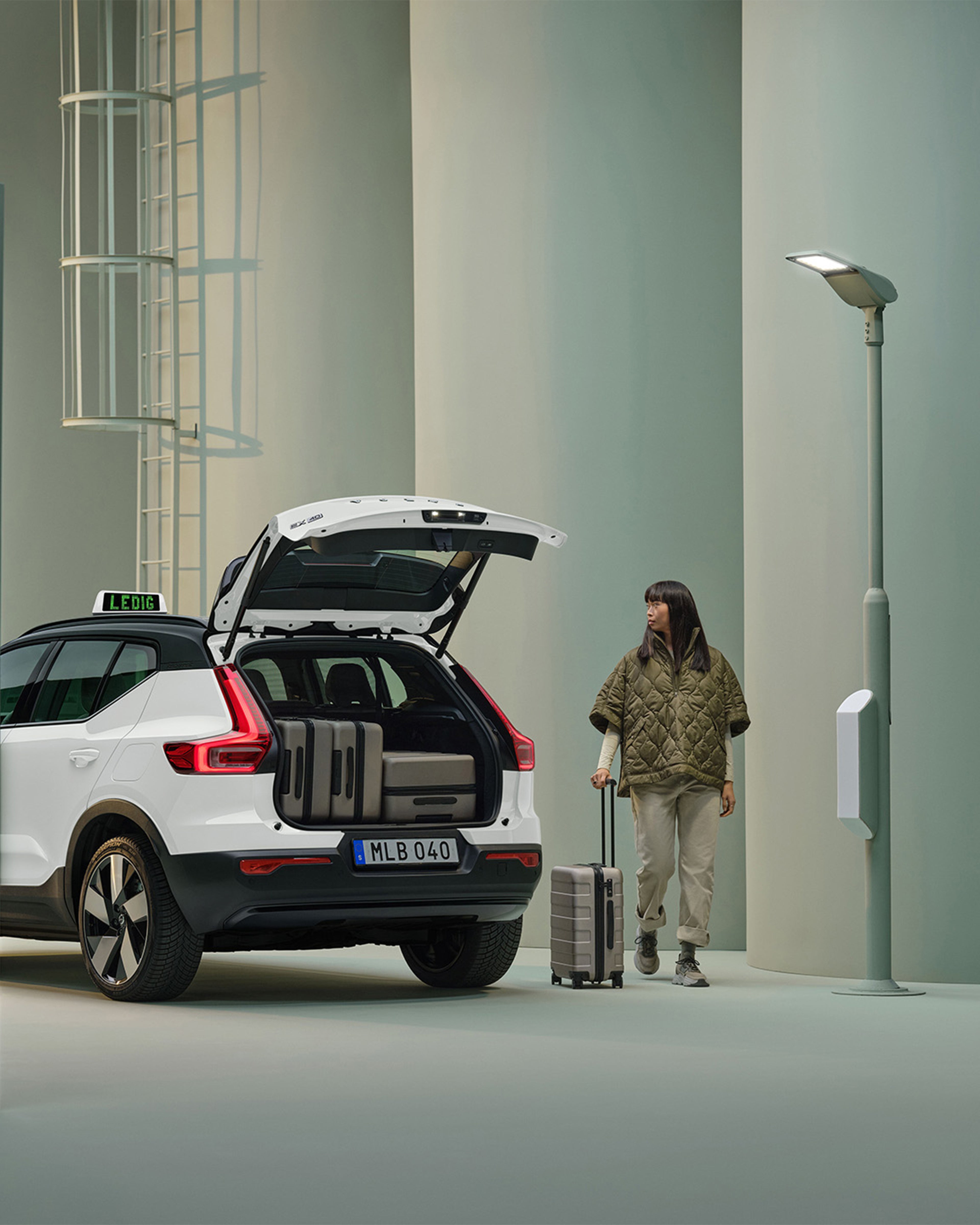 Kvinna står bredvid vit Volvo EX40