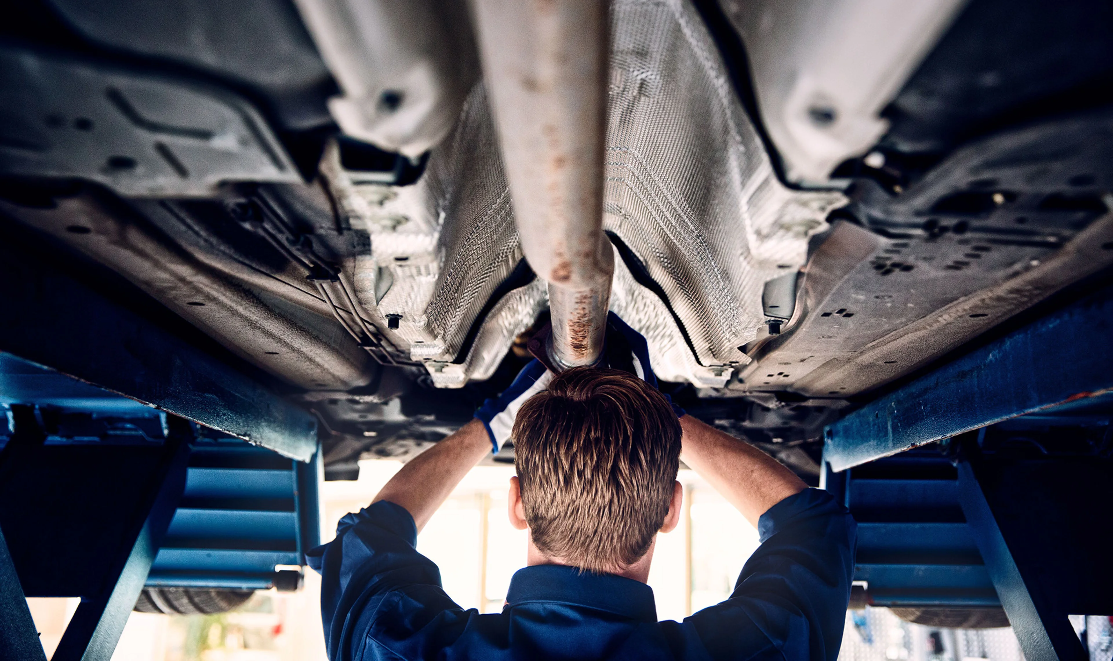Técnico Volvo debaixo de um Volvo suspenso