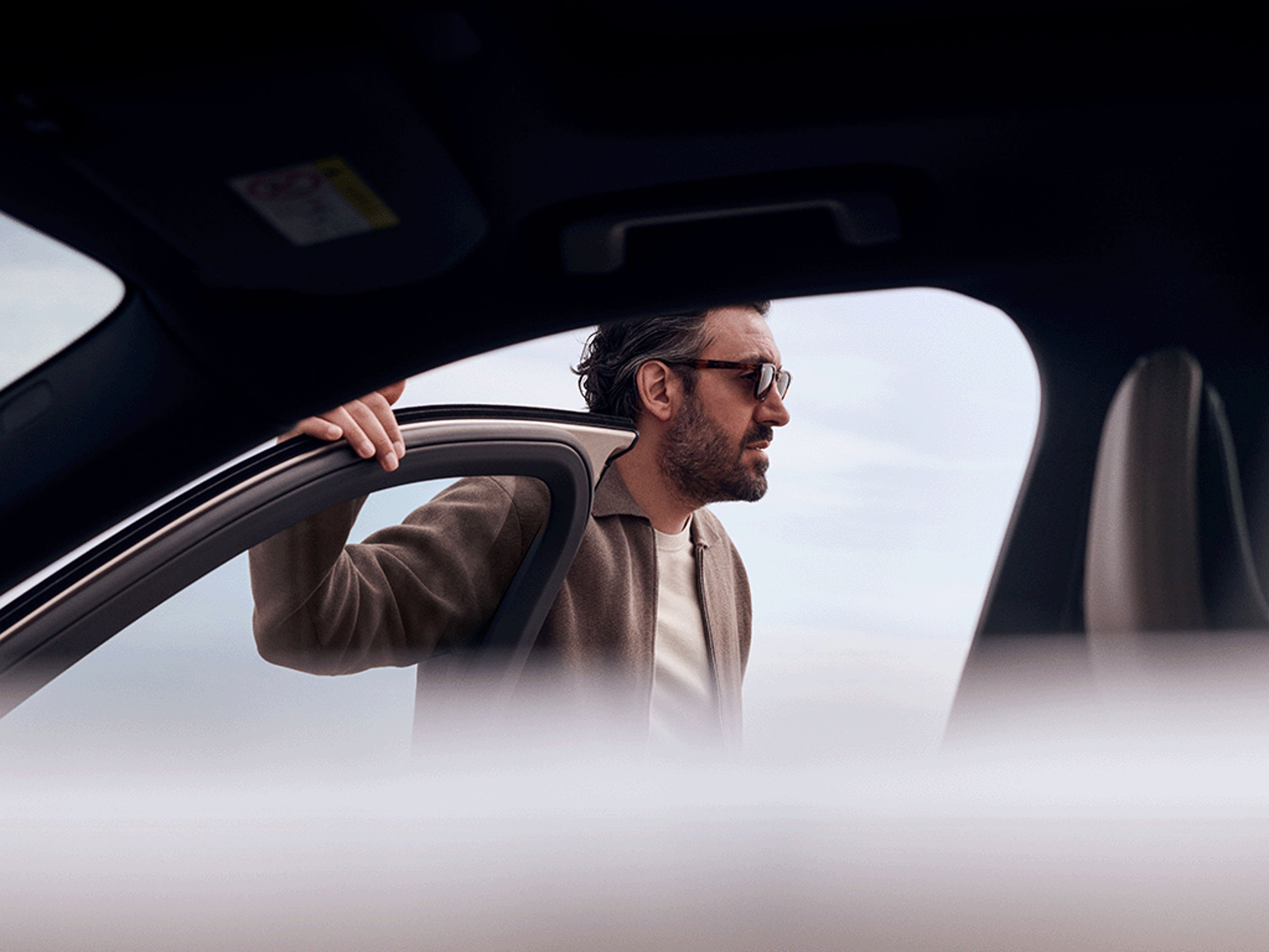 Ein Mann steht an einer geöffneten Tür eines Volvo XC90.