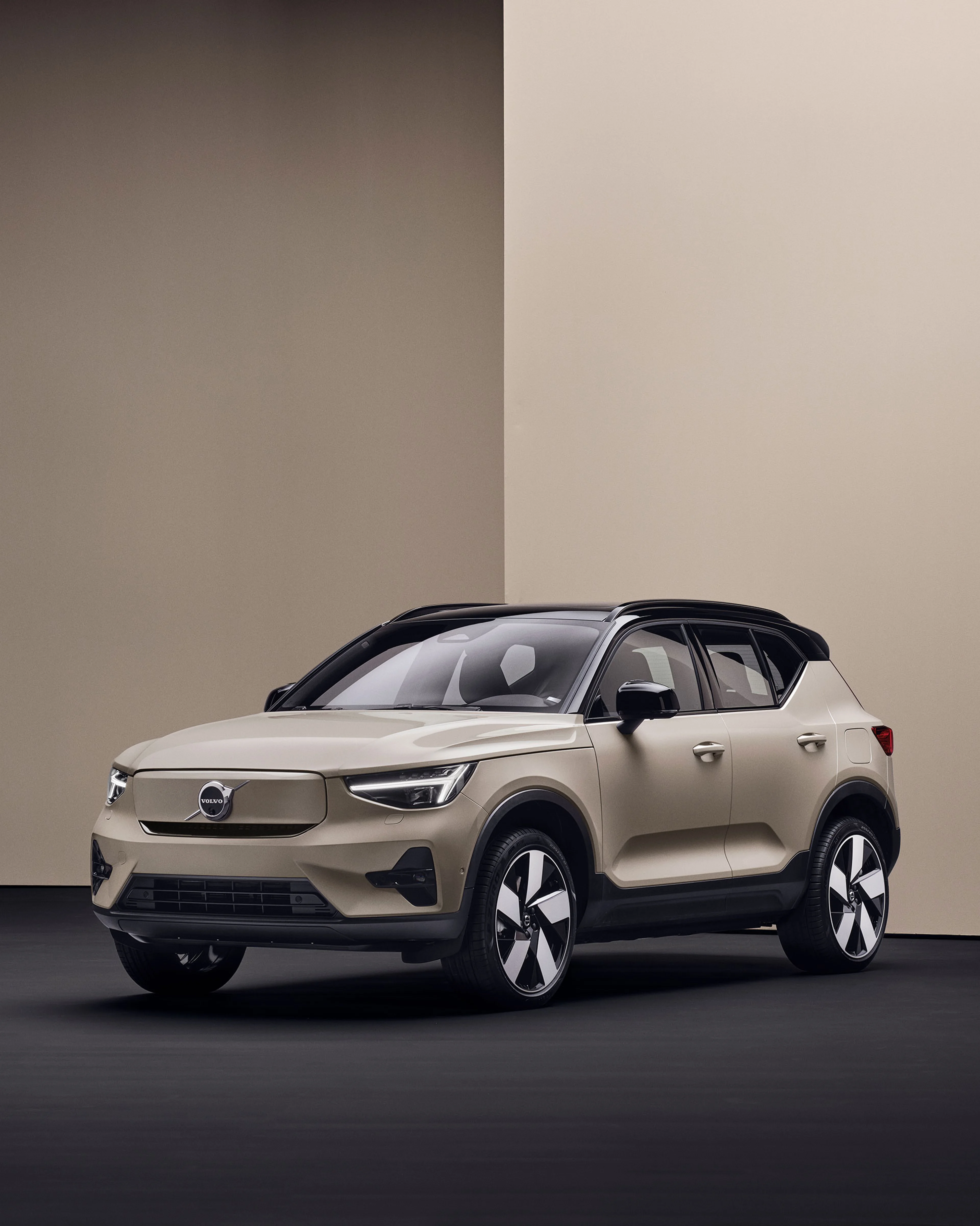 Volvo EX40 beige garé dans un décor moderne et minimaliste, avec murs beiges et sol foncé
