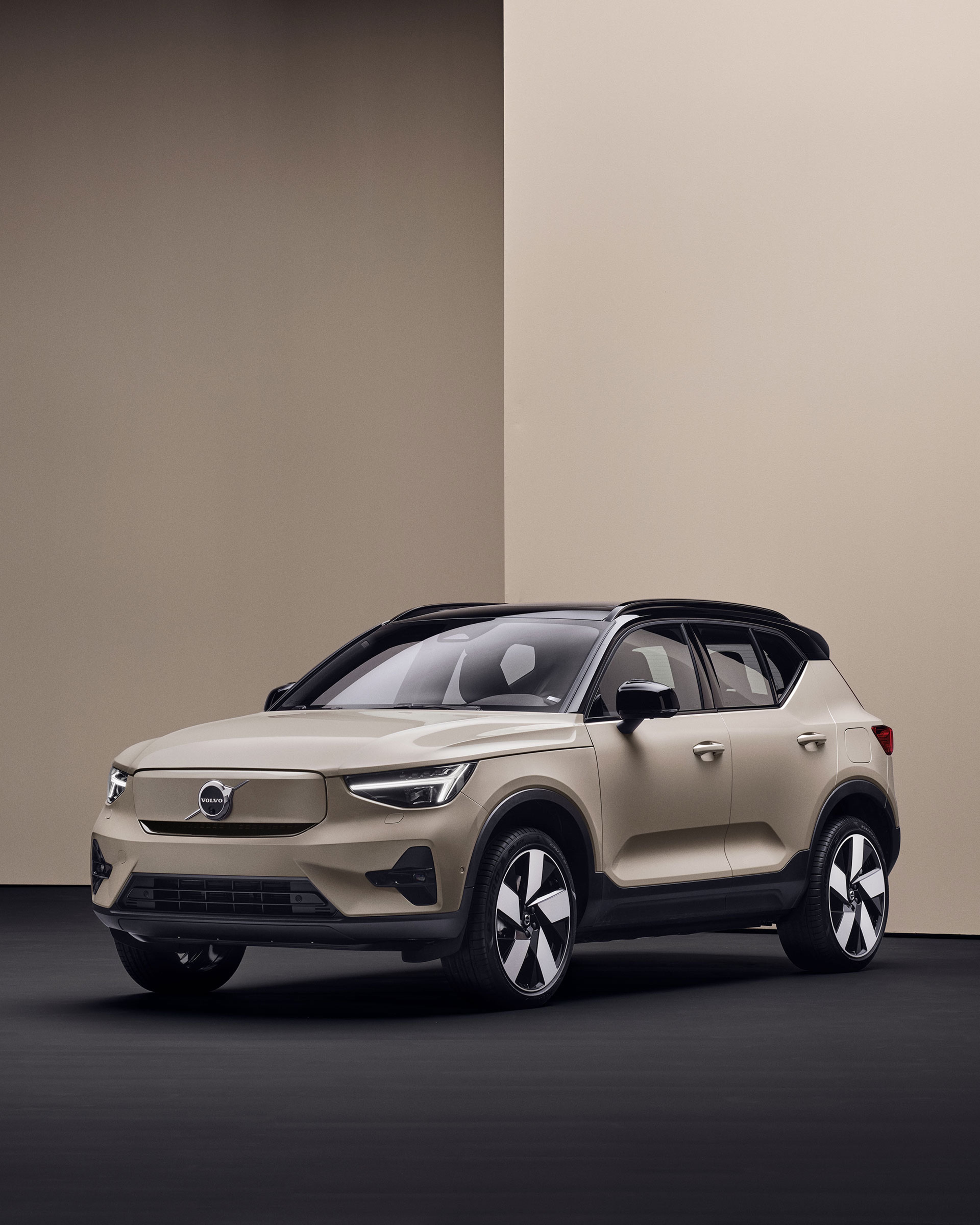 Volvo EX40 beige garé dans un décor moderne et minimaliste, avec murs beiges et sol foncé