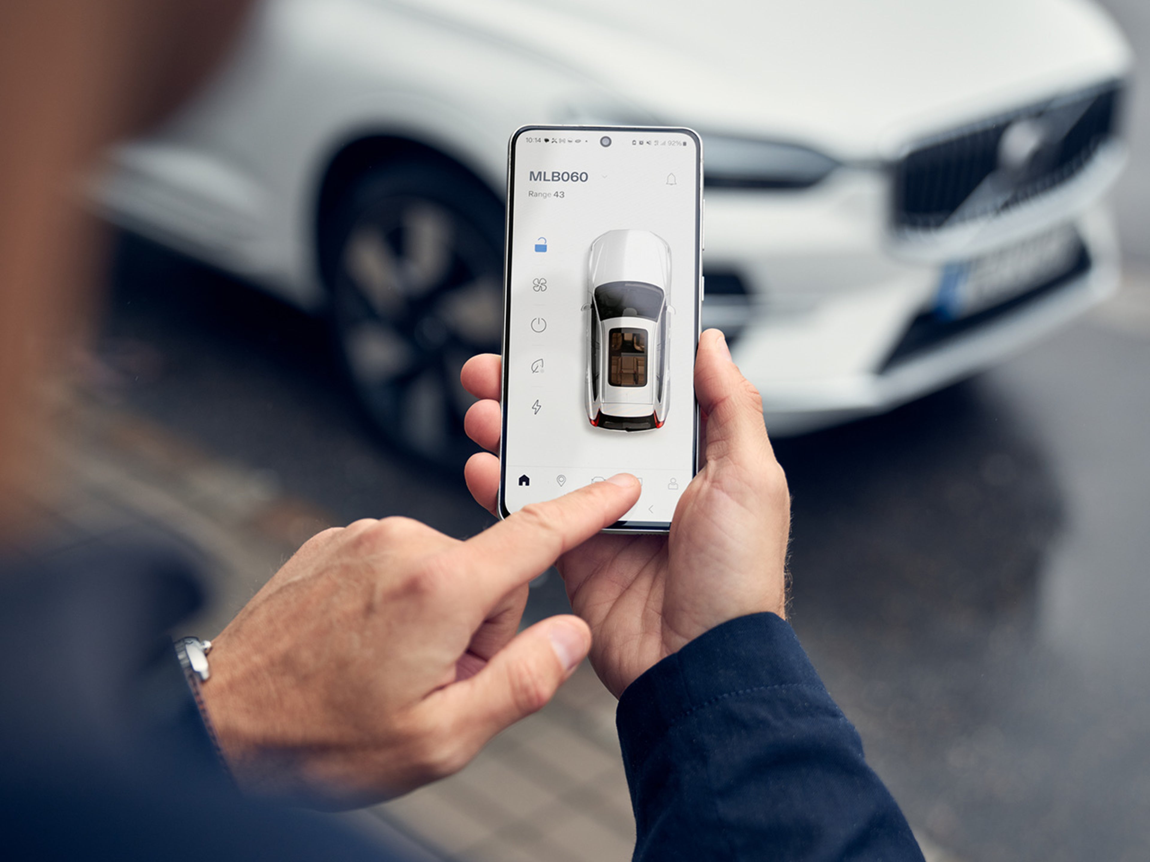 An image of a phone in hand, showcasing the Volvo cars app.