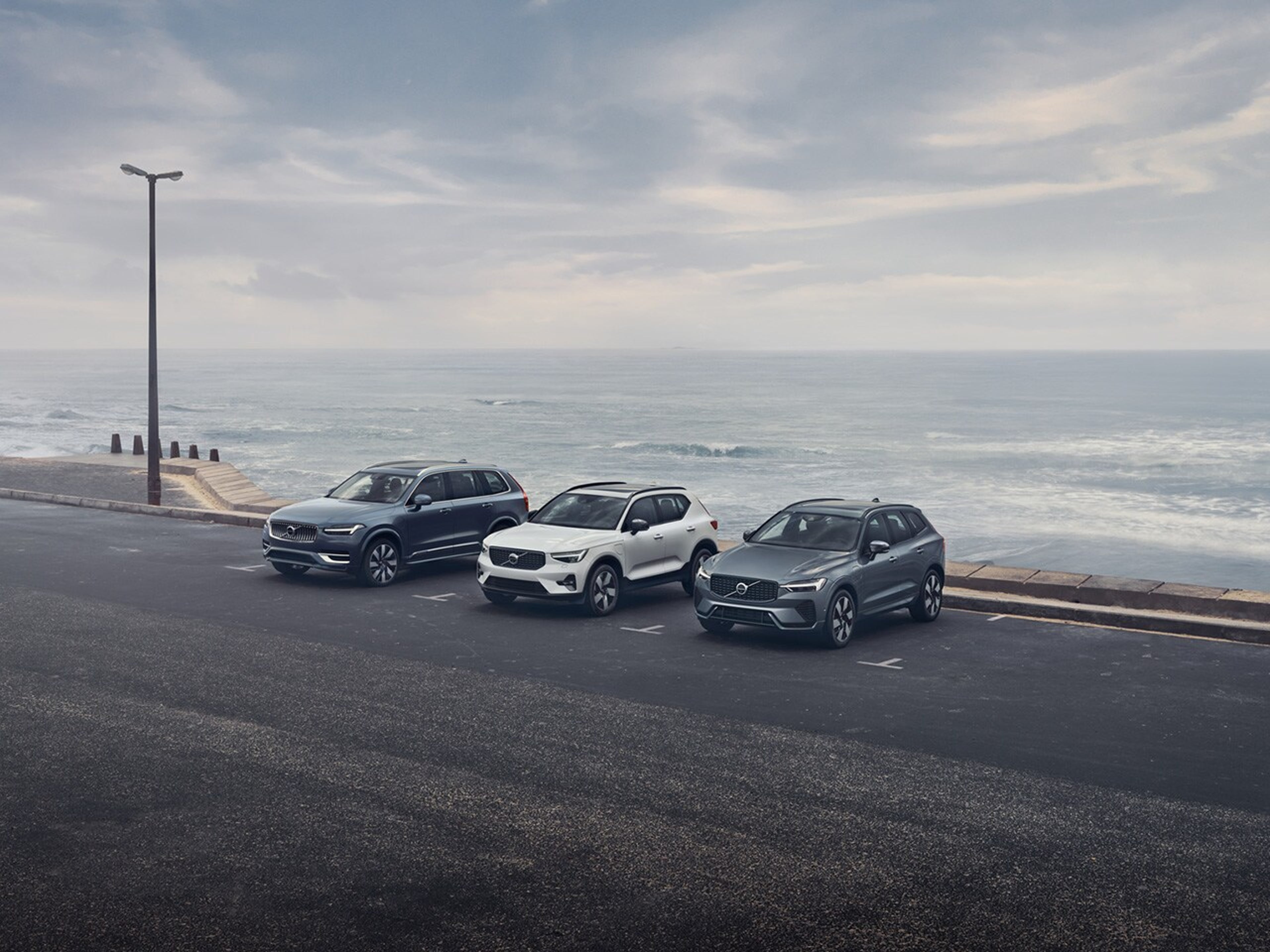 Volvo modellek parkolnak egy tenger melletti parkolóban