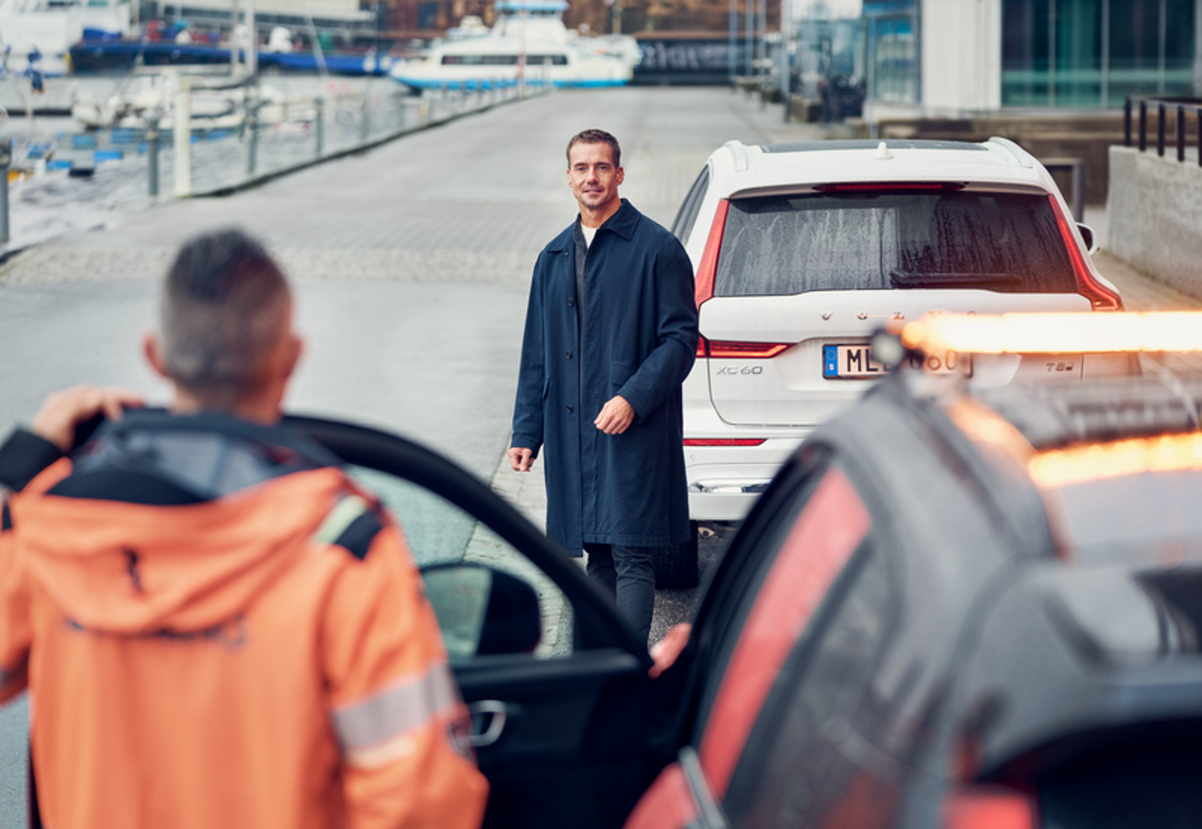 Mężczyzna stojący przy Volvo i czekający na pomoc drogową