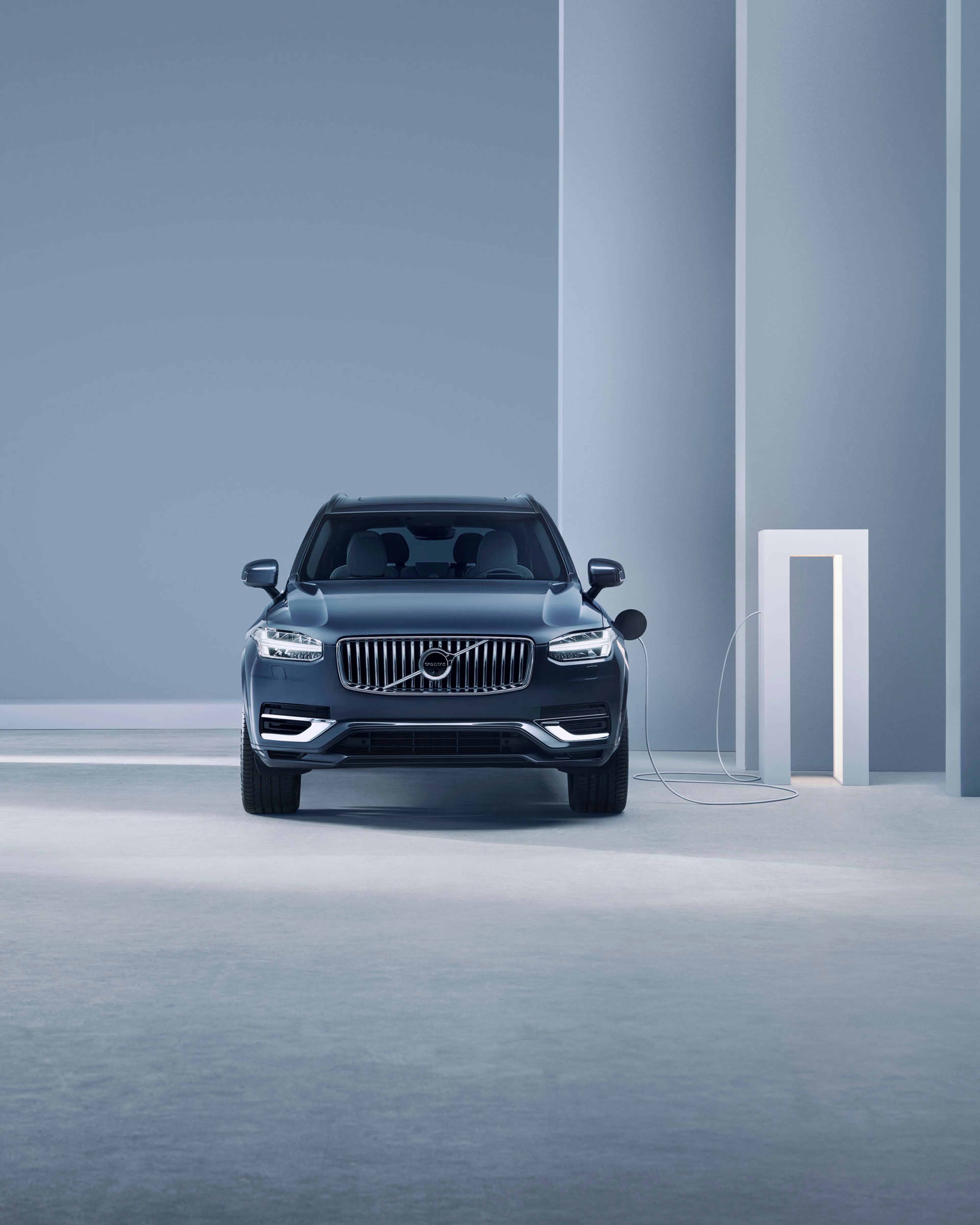 Volvo XC90 vista frontal al lado de una estación de carga