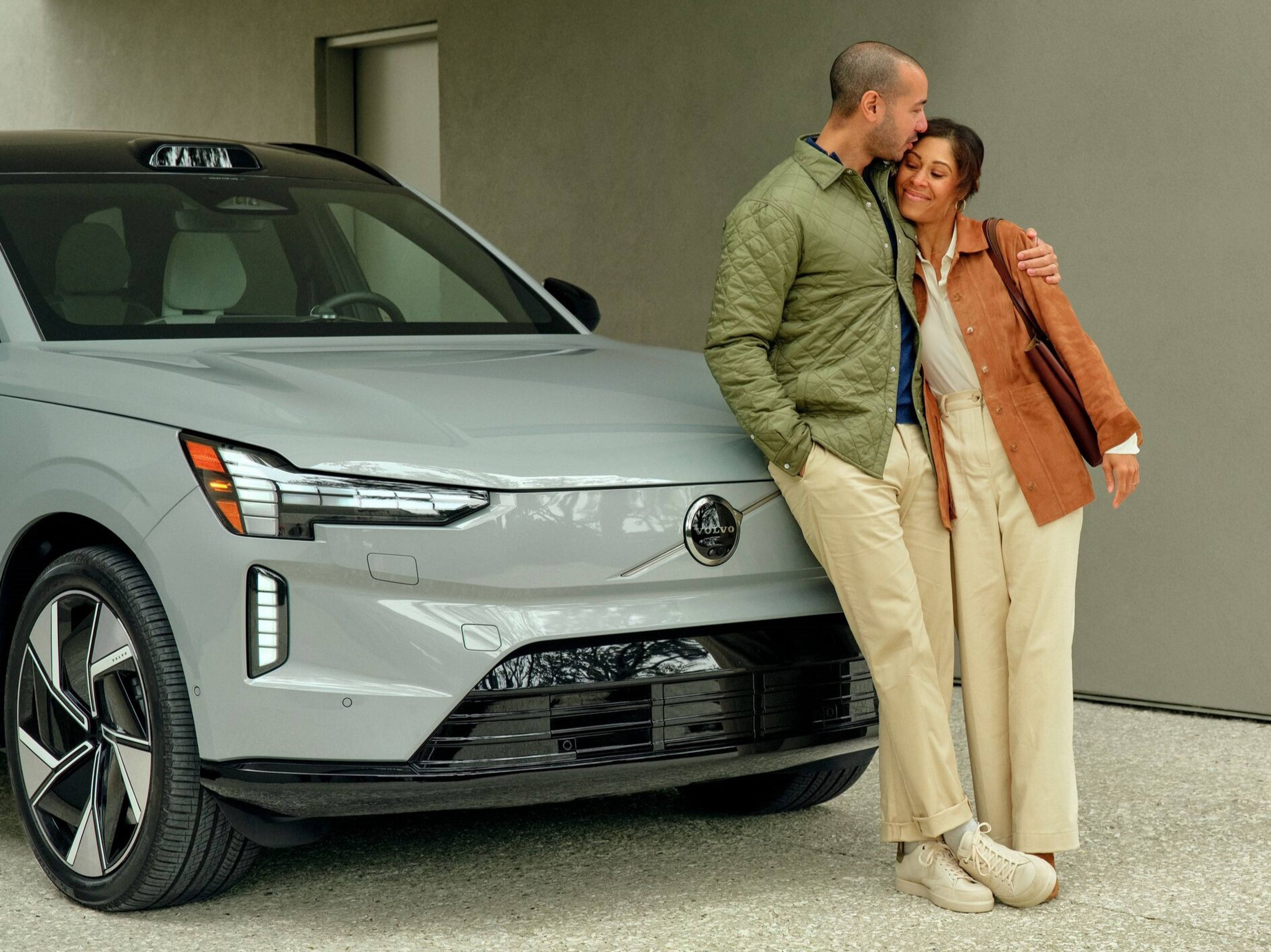 Two people standing in front of Volvo EX90