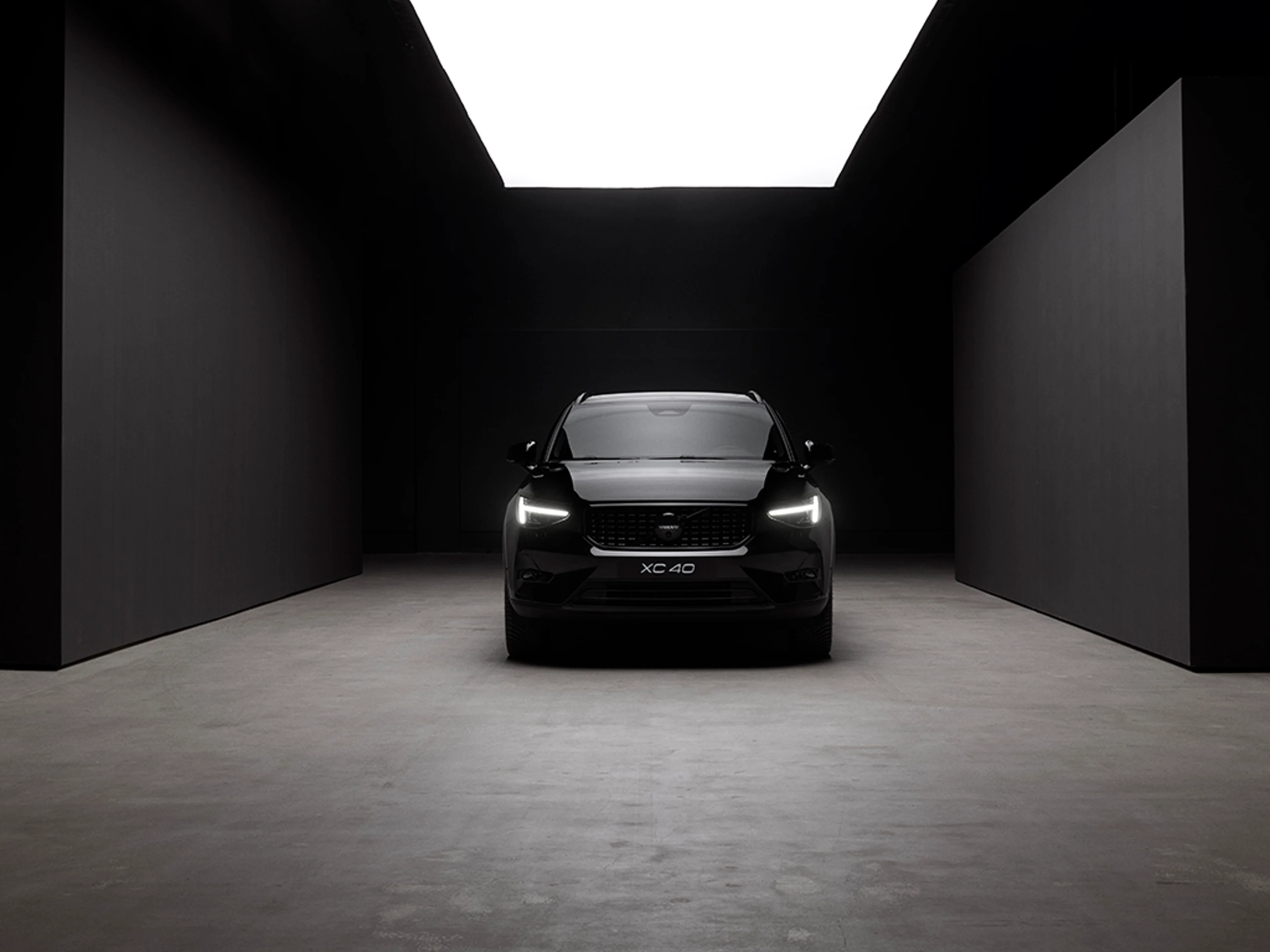 Czarne Volvo XC40 pokazane przodem w zabudowanej przestrzeni