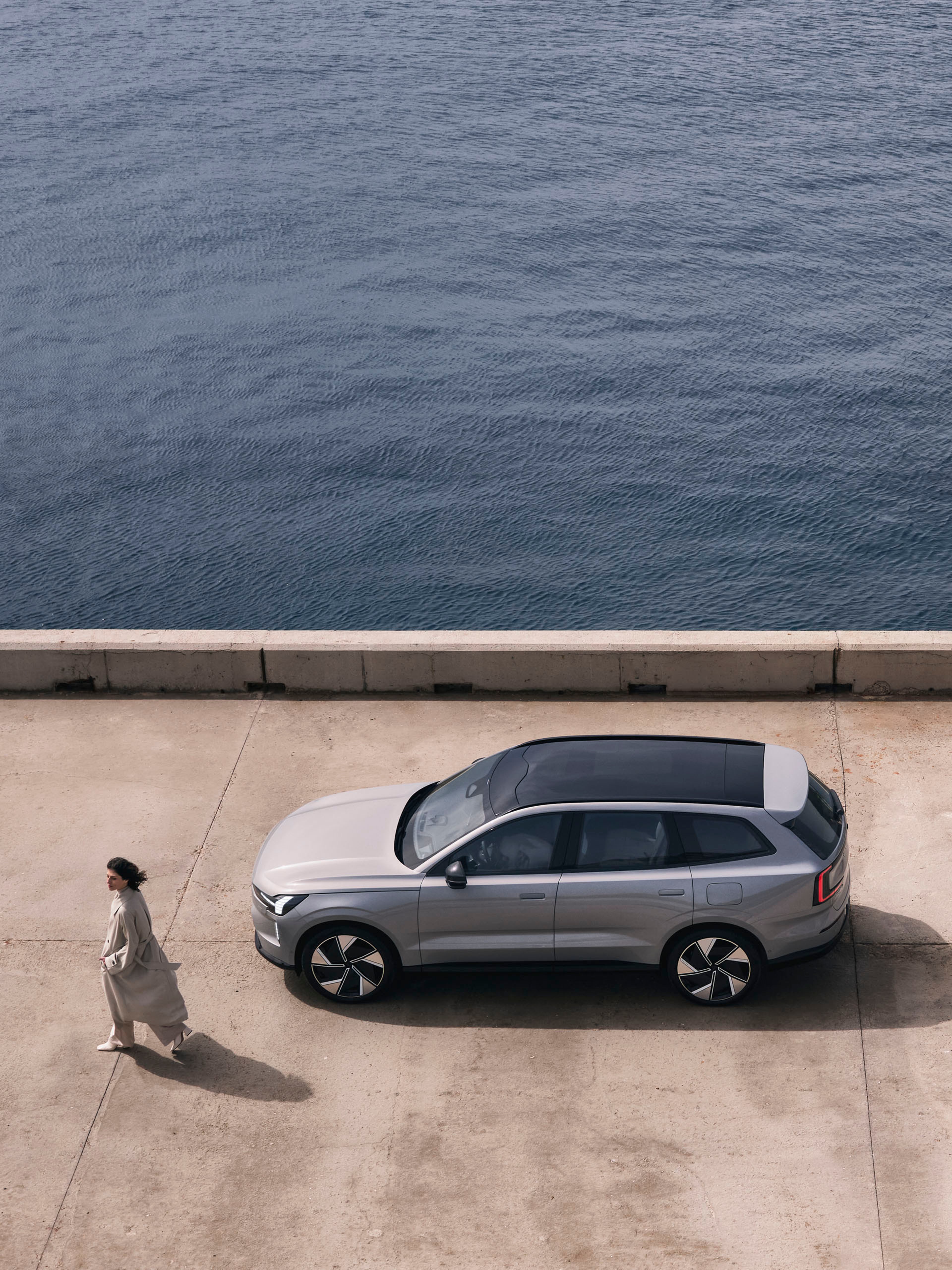 Un Volvo EX90 con el techo solar en color gris metalizado junto al mar