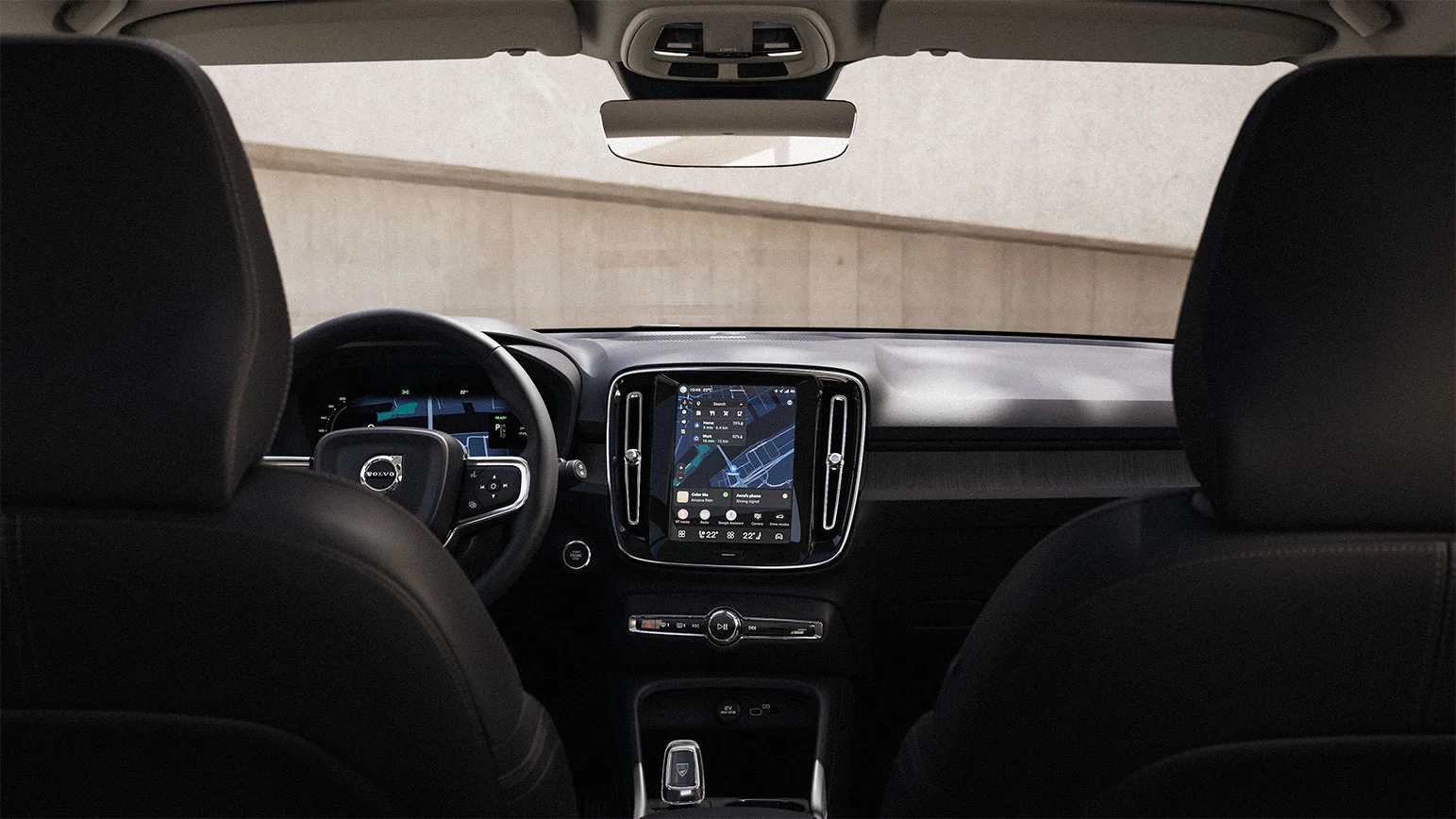 Vue intérieure d’une Volvo avec tableau de bord, volant Volvo et écran tactile central affichant la navigation