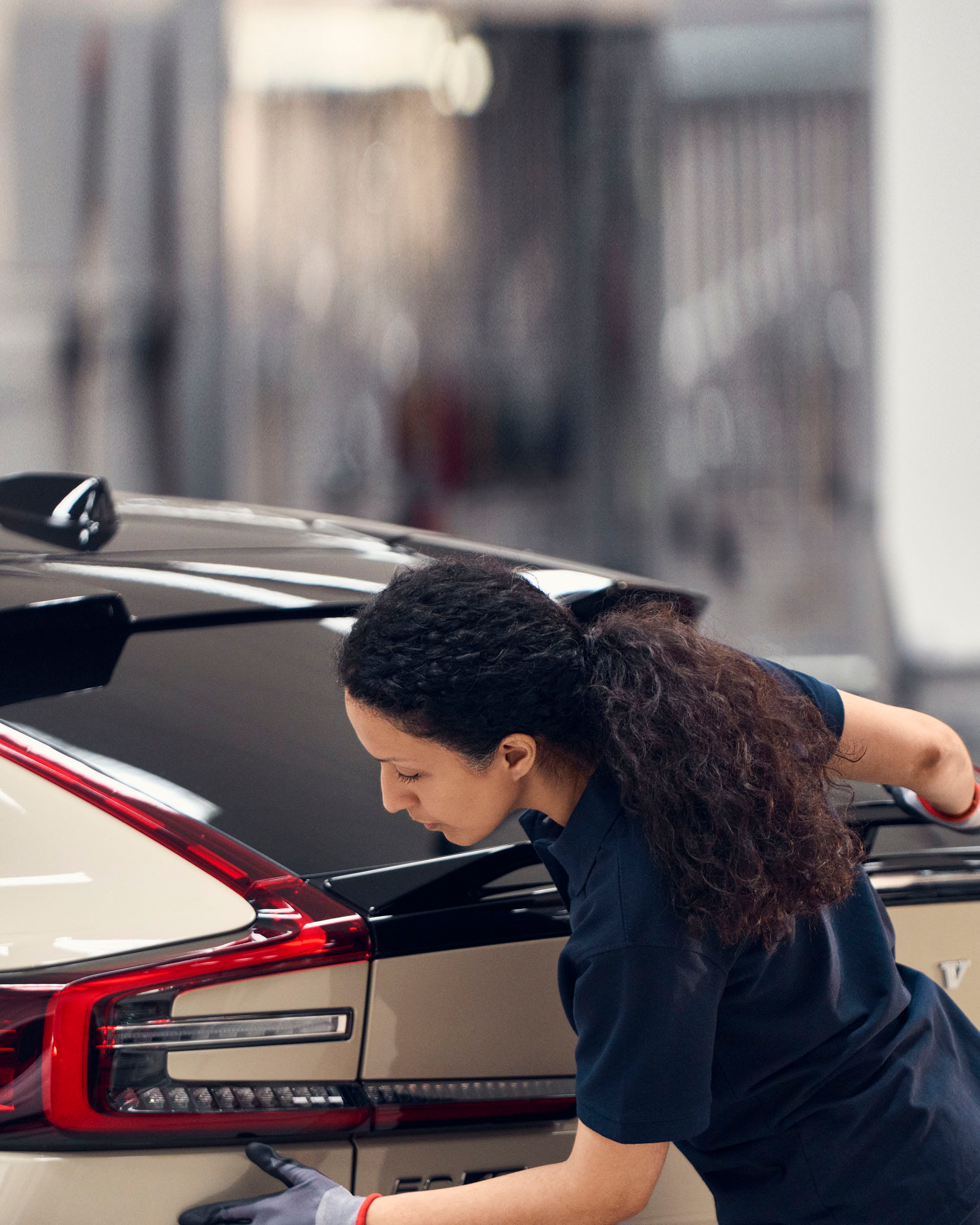 Una técnica de taller revisando un vehículo Volvo