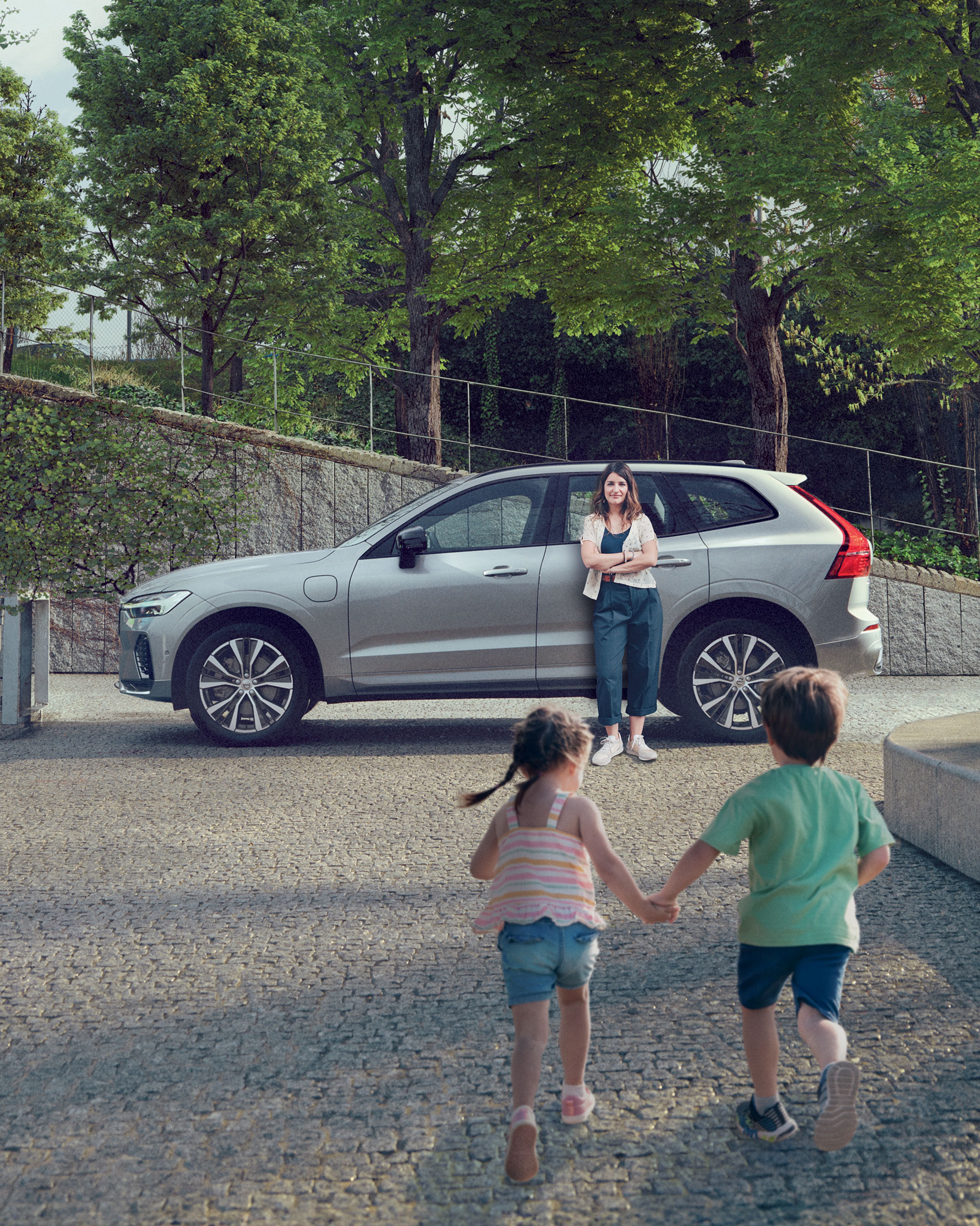 Groupe d’enfants sortant du foot et courant vers leur mère adossée à un XC60 gris argenté