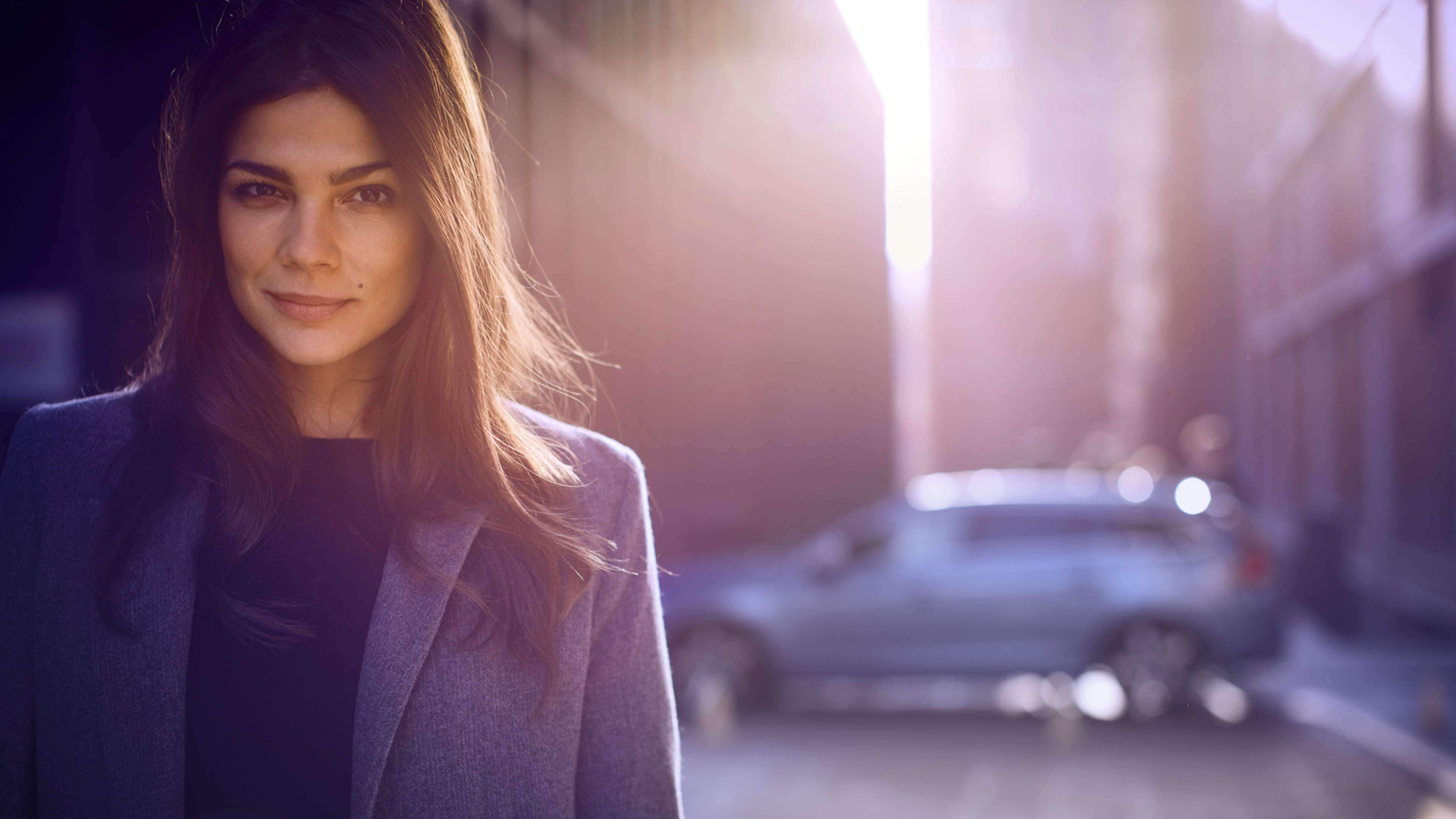 Femme devant une voiture Volvo de profil