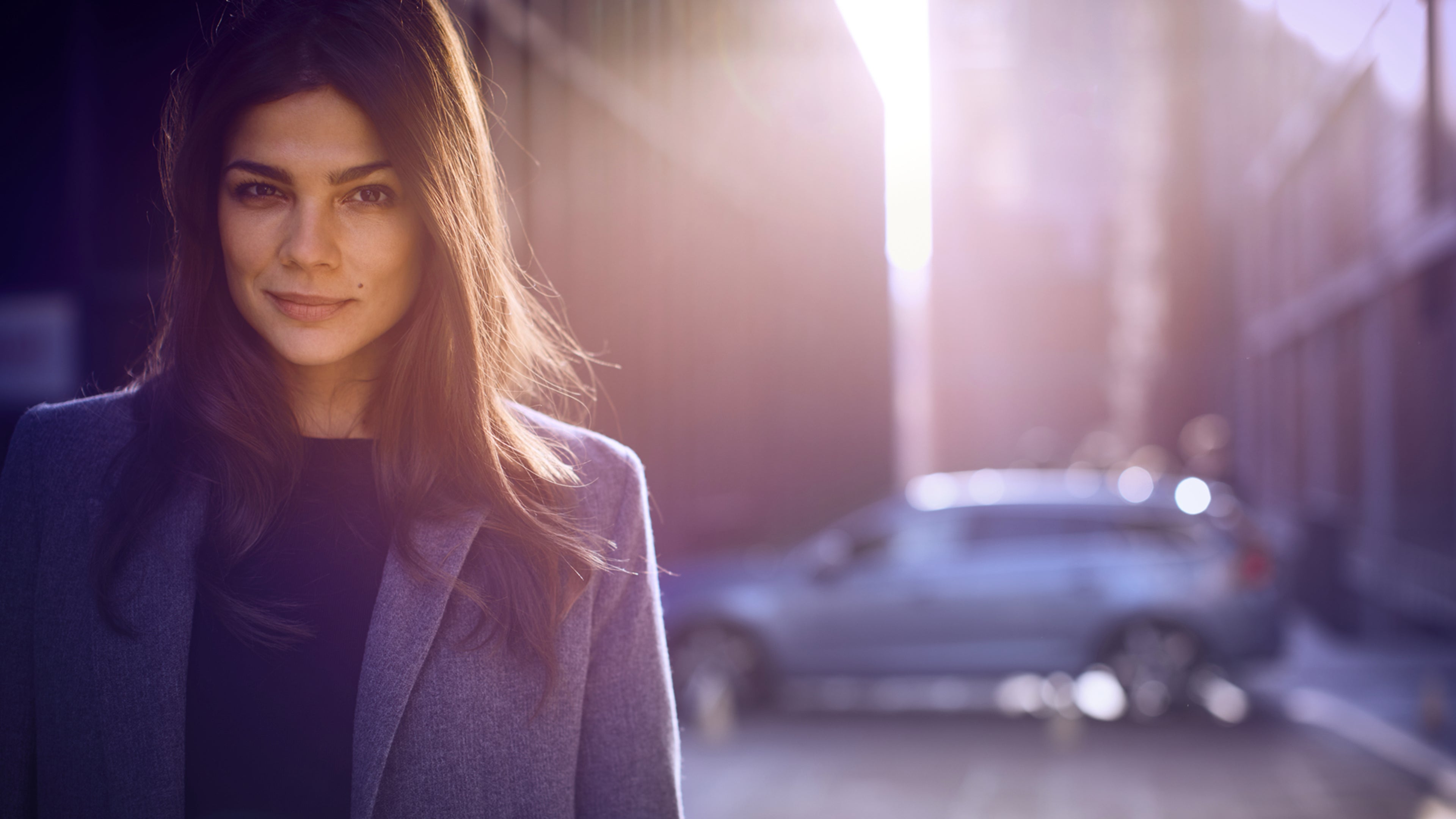 Femme devant une voiture Volvo de profil