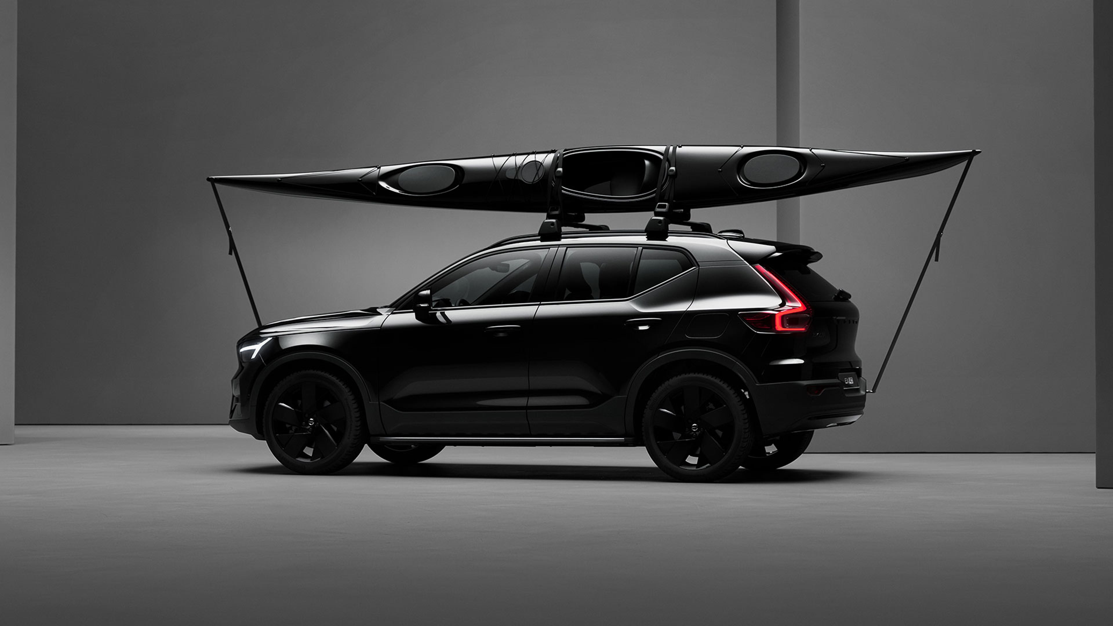EX40 Black Edition vu de côté dans un décor de studio avec un kayak arrimé au porte-kayak sur le toit.