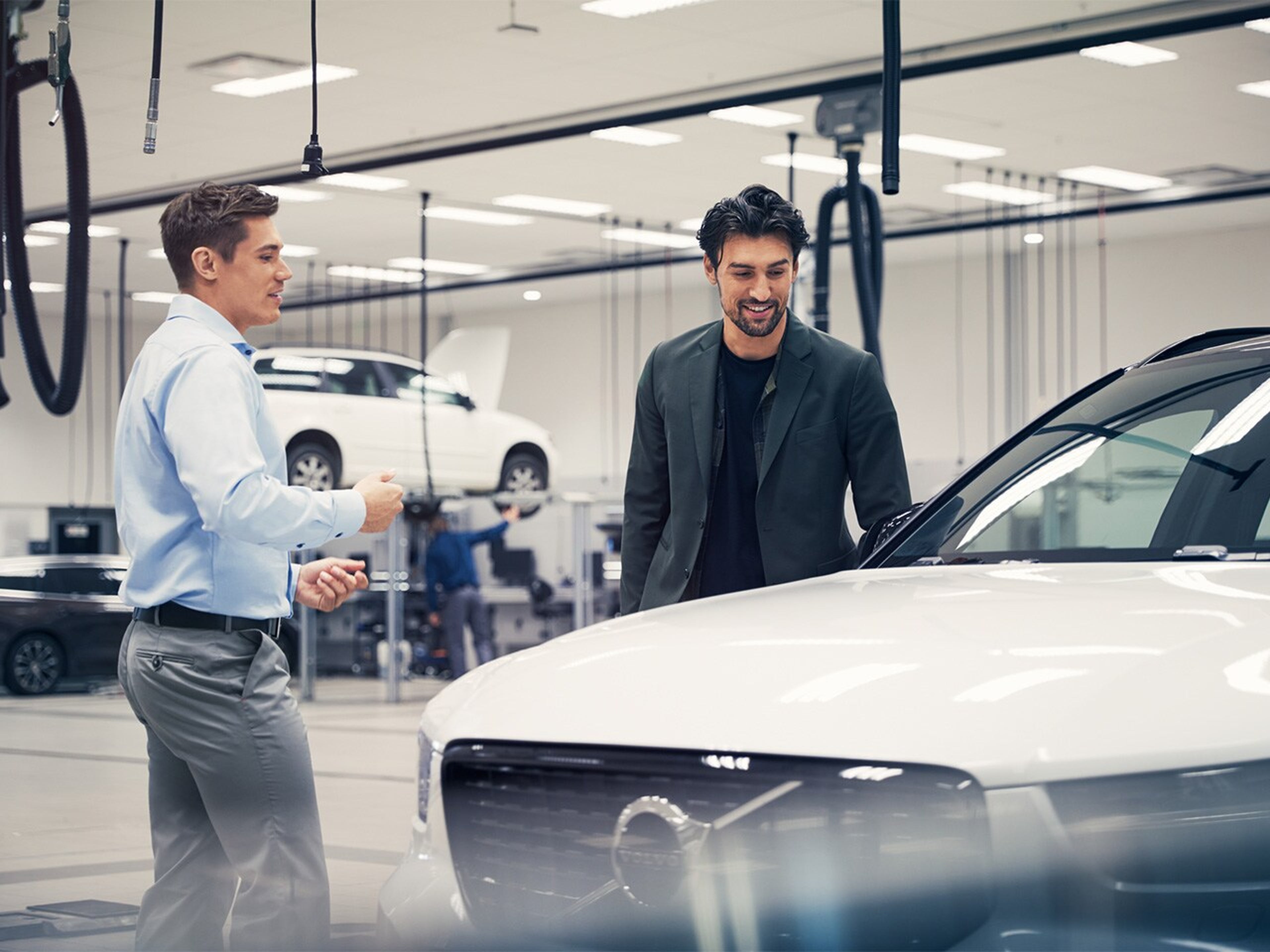 Egy ügyfél szemügyre vesz egy Volvo modellt a márkakereskedésben